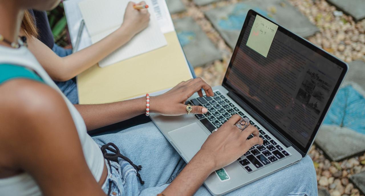 Studying on a laptop with a notebook for continuing education