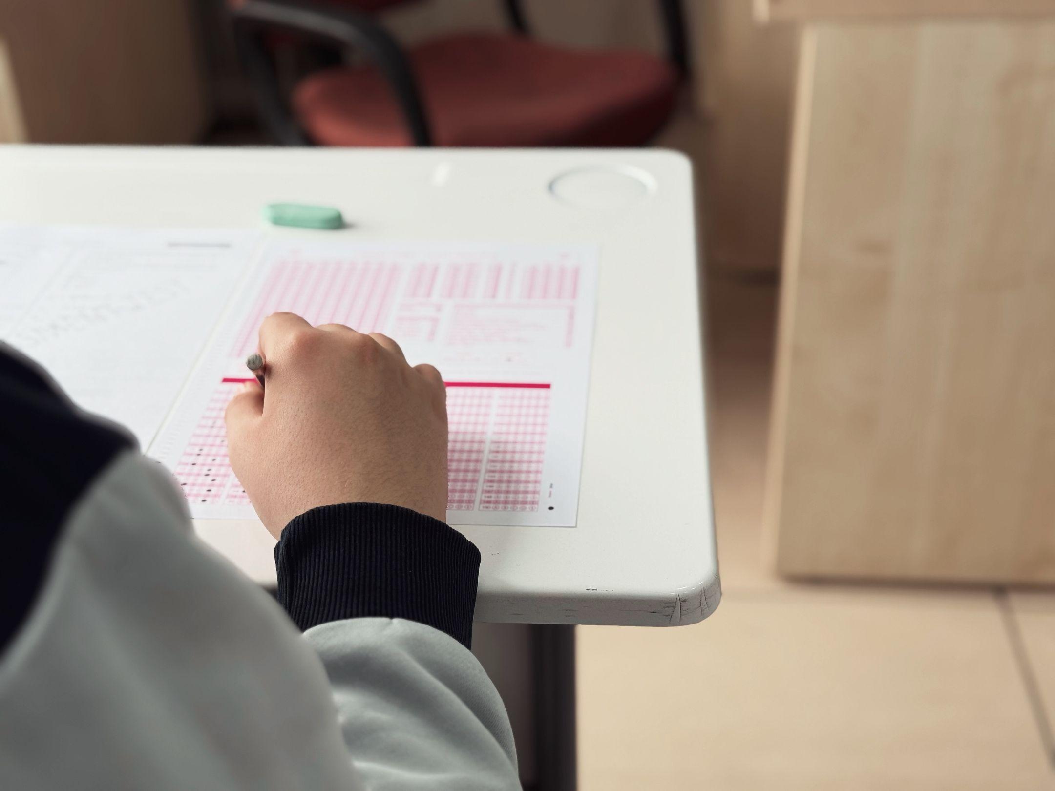 Close-up of student answering a test in a classroom environment.