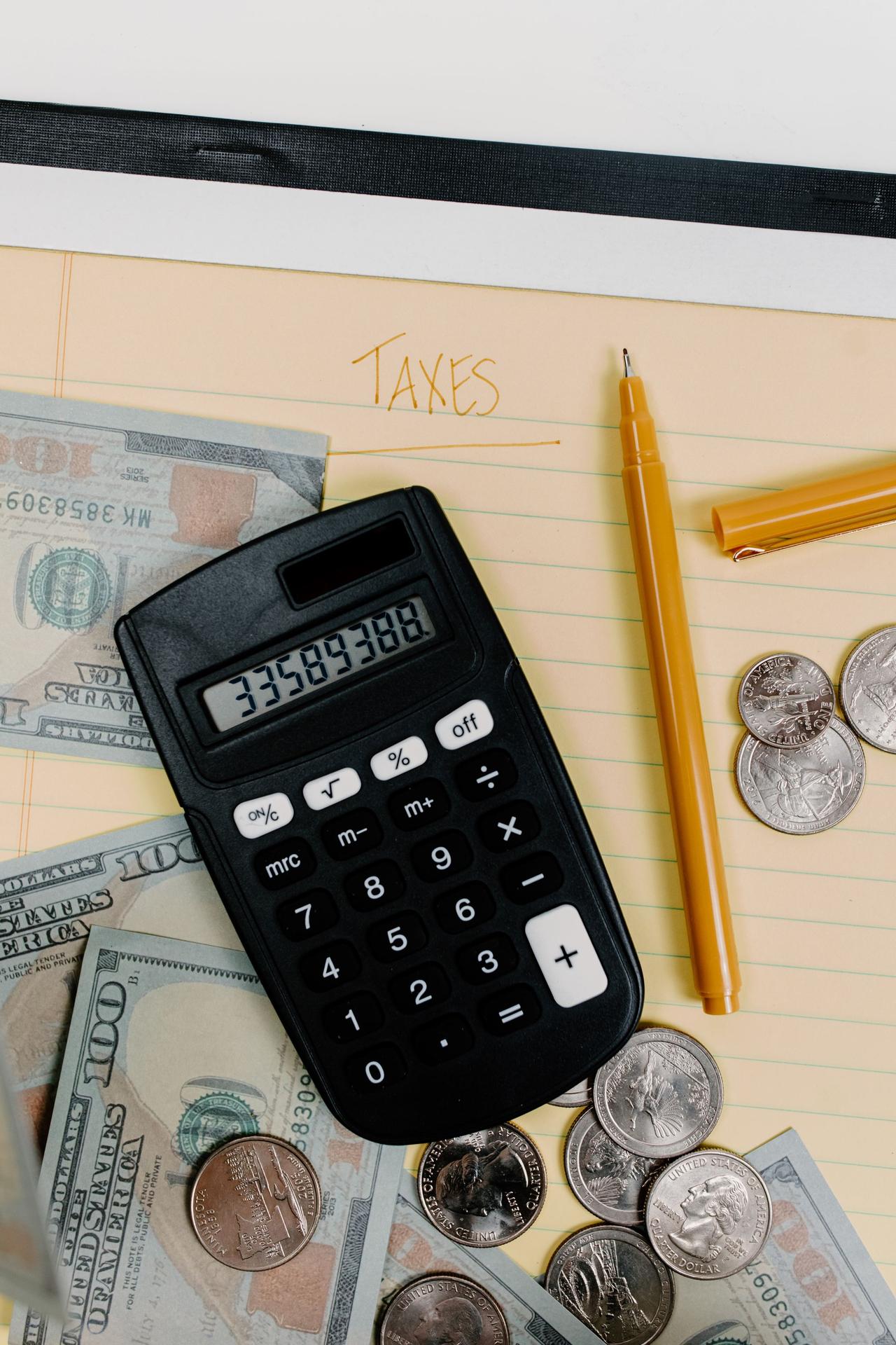 Calculator, cash and a pen on top of a property tax bill