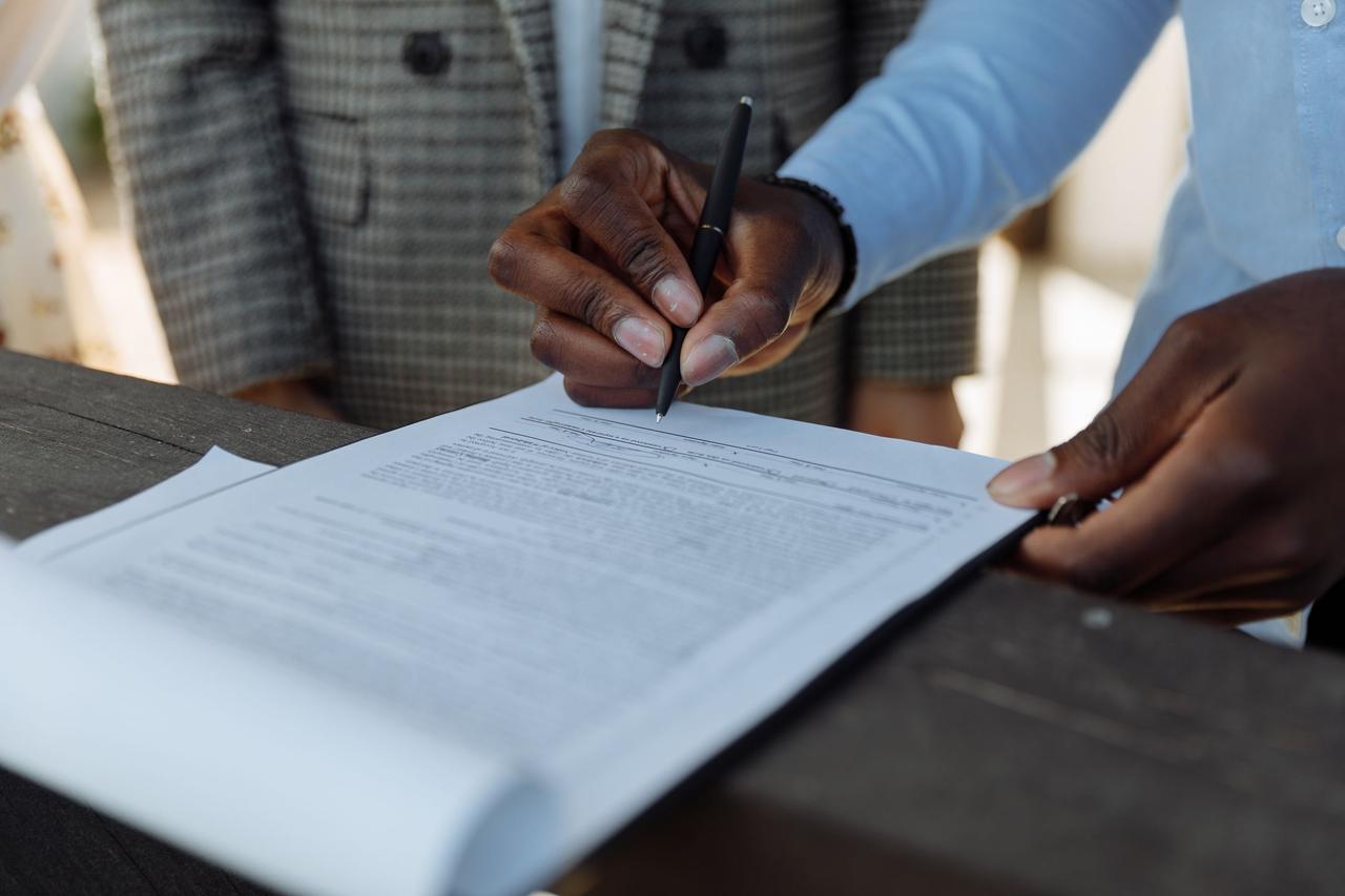 Two people signing a real estate agreement