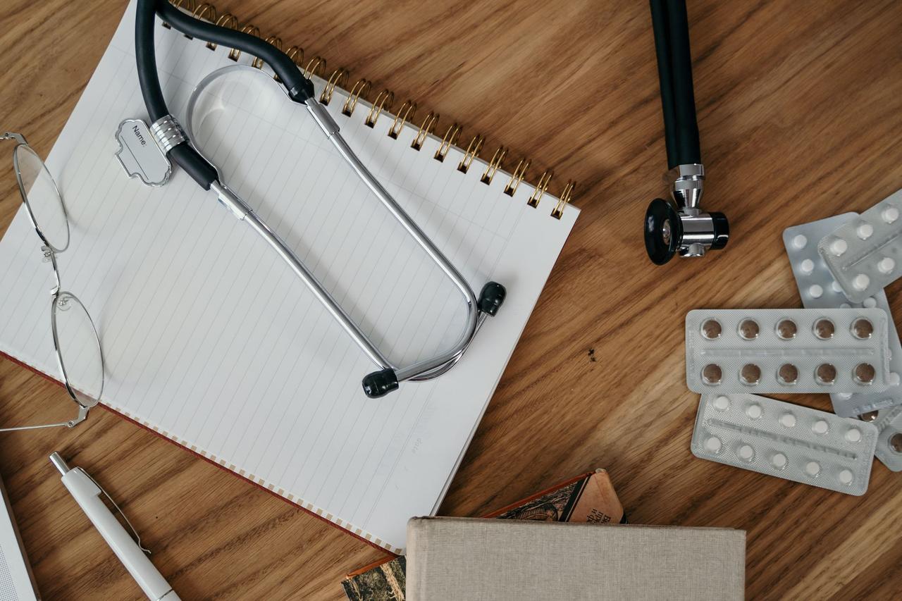 Stethoscope and medical bills on a wooden table