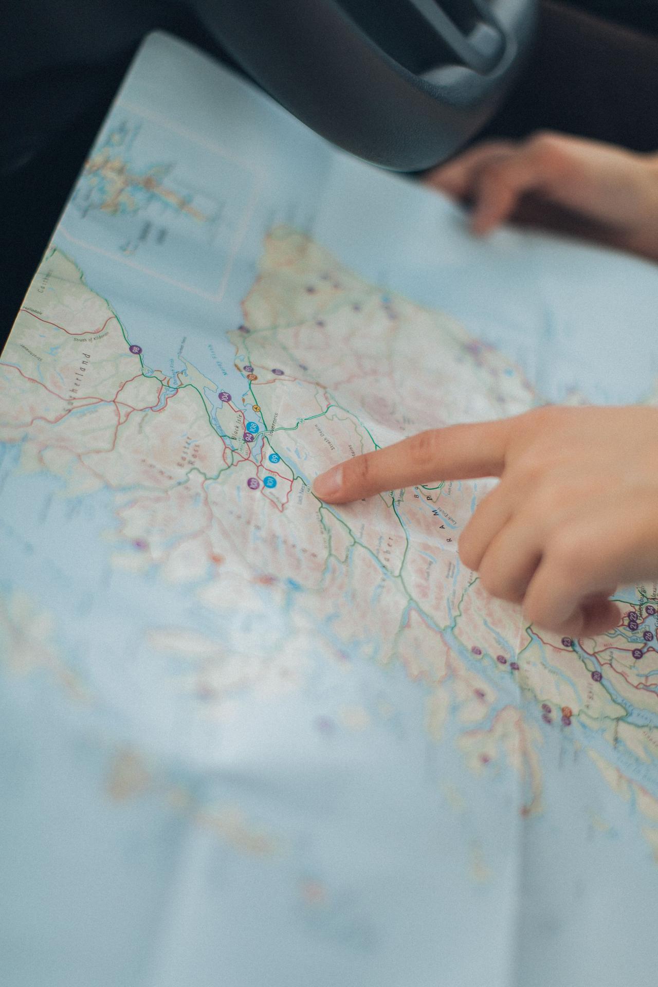 Finger pointing to a destination on a map