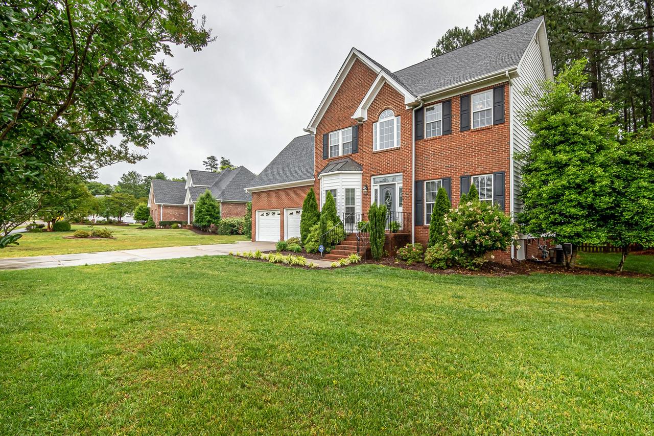 Brick two-story house with a front lawn