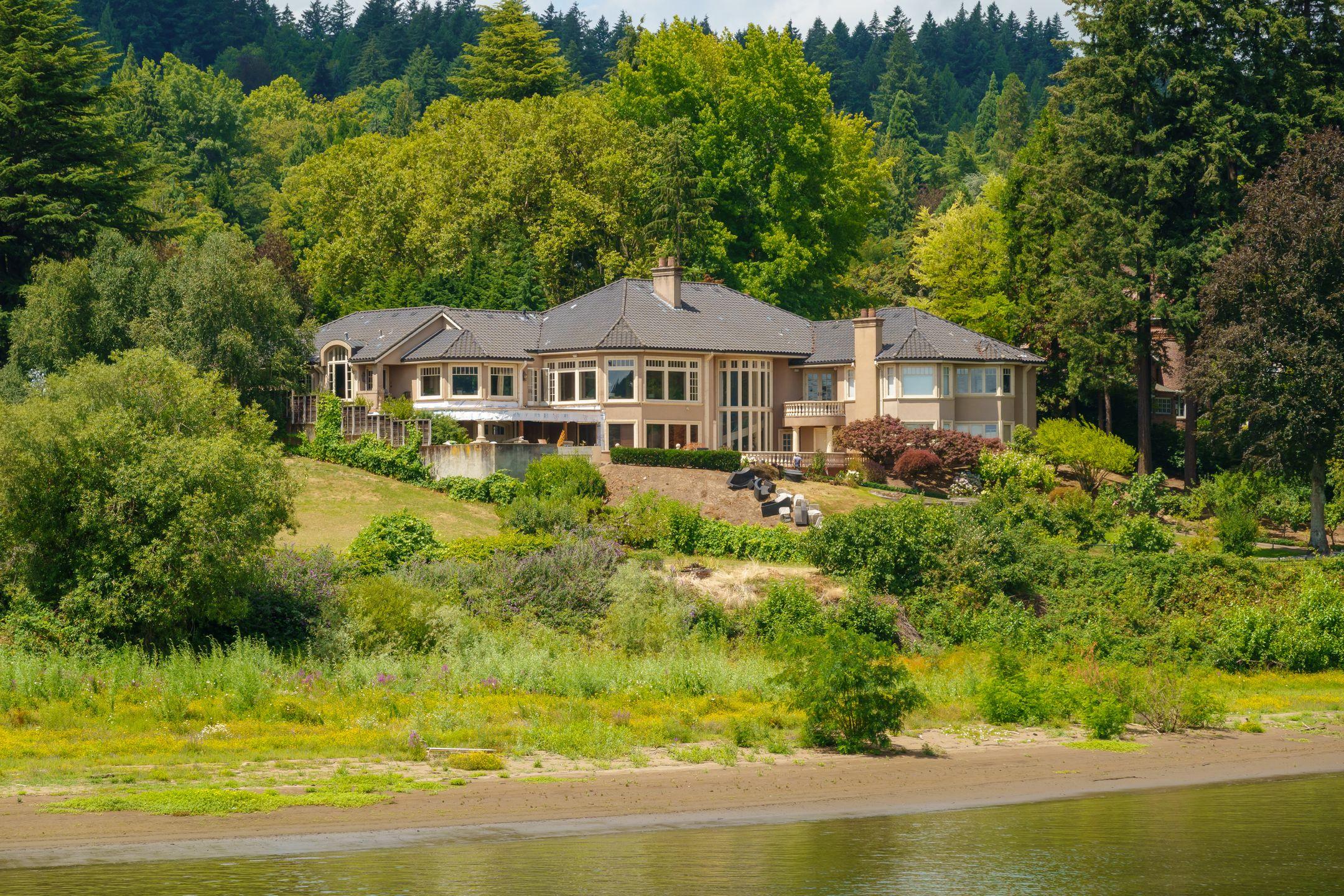 A beautiful luxury home by the water with lush forest surroundings in spring.