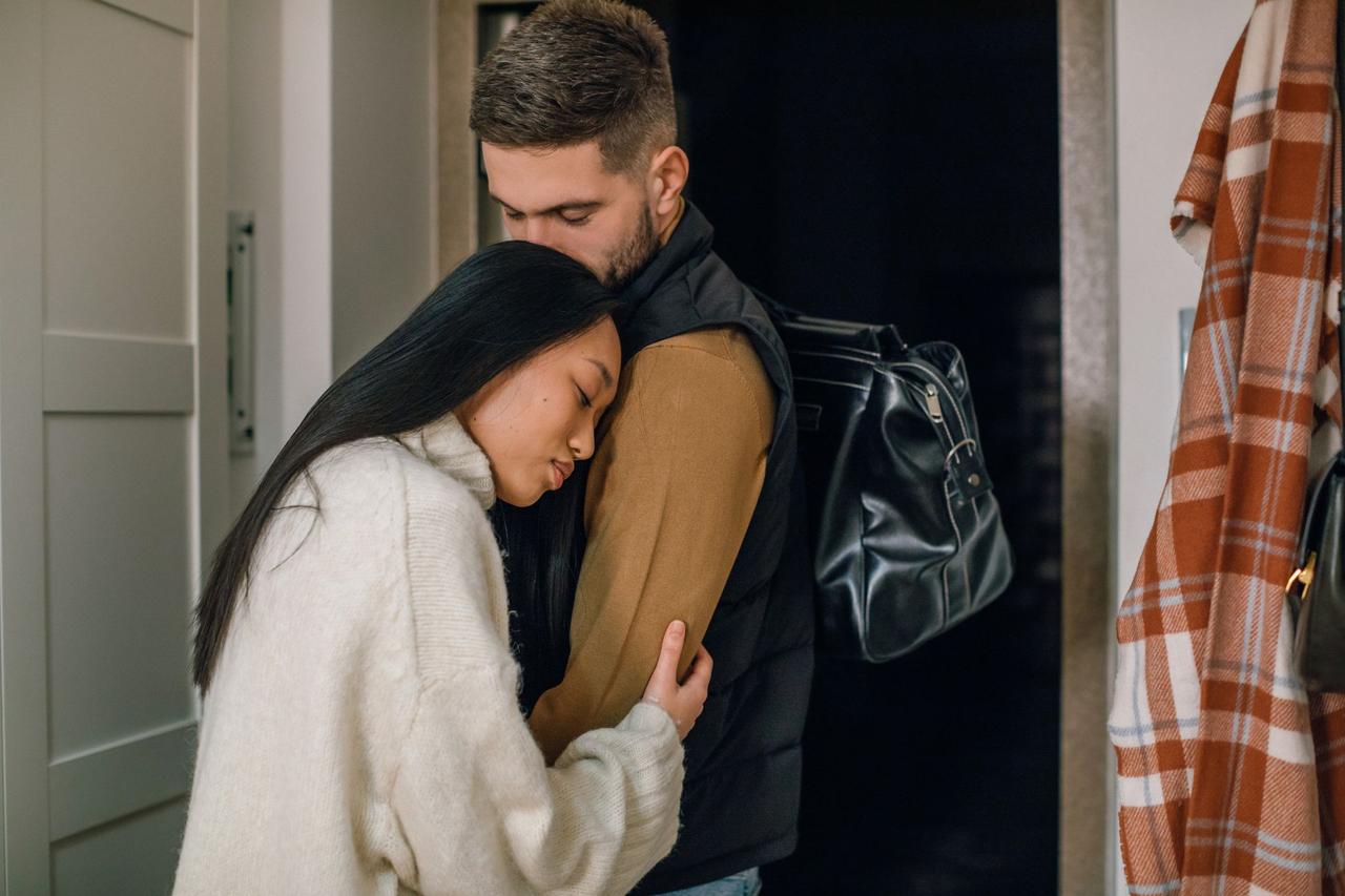 An intimate moment of a couple embracing warmly indoors, radiating affection and connection.