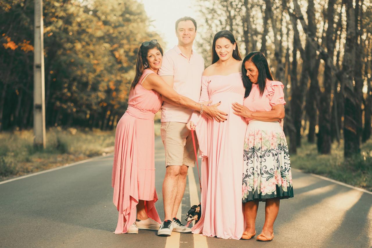 Family celebrating pregnancy on a sunlit road, showcasing joy and anticipation.