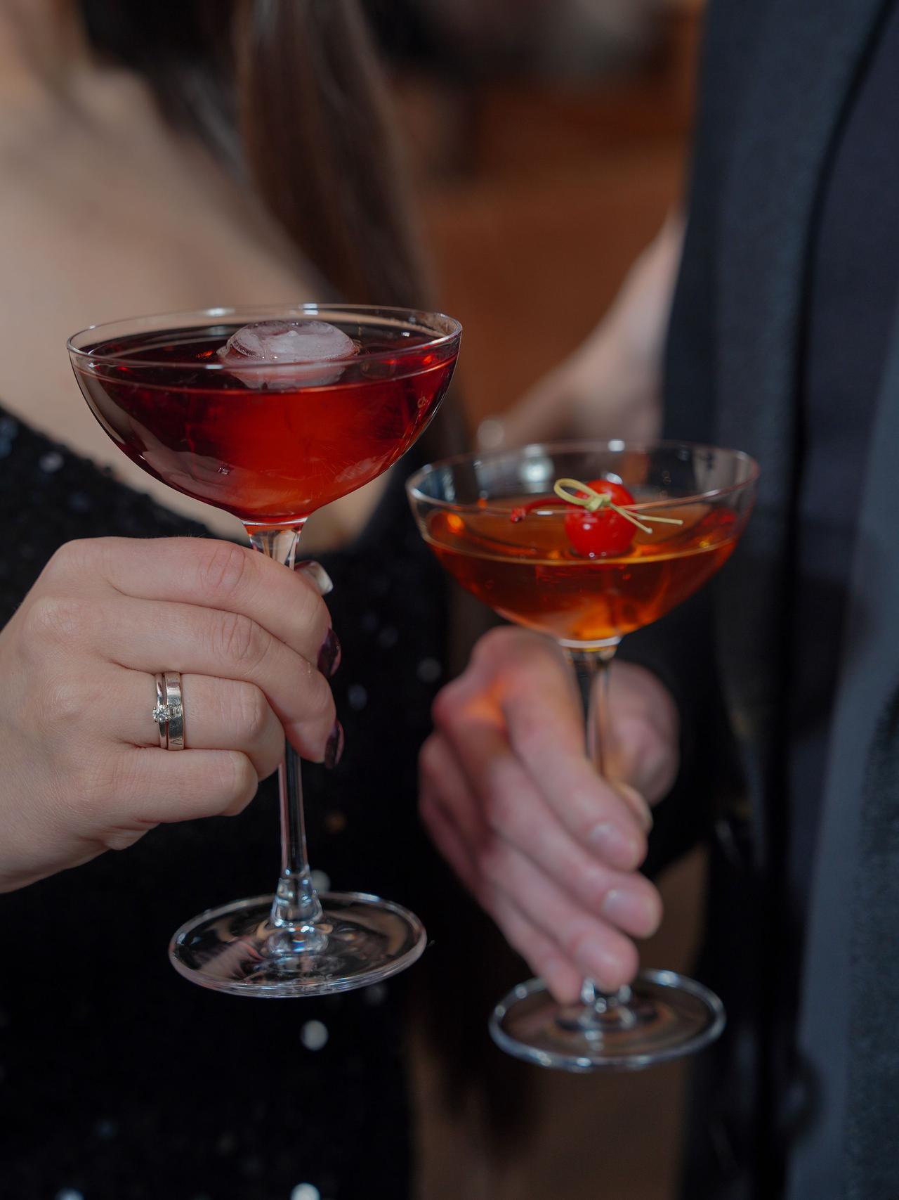 Close-up of couple toasting with cocktails, celebrating a special occasion.