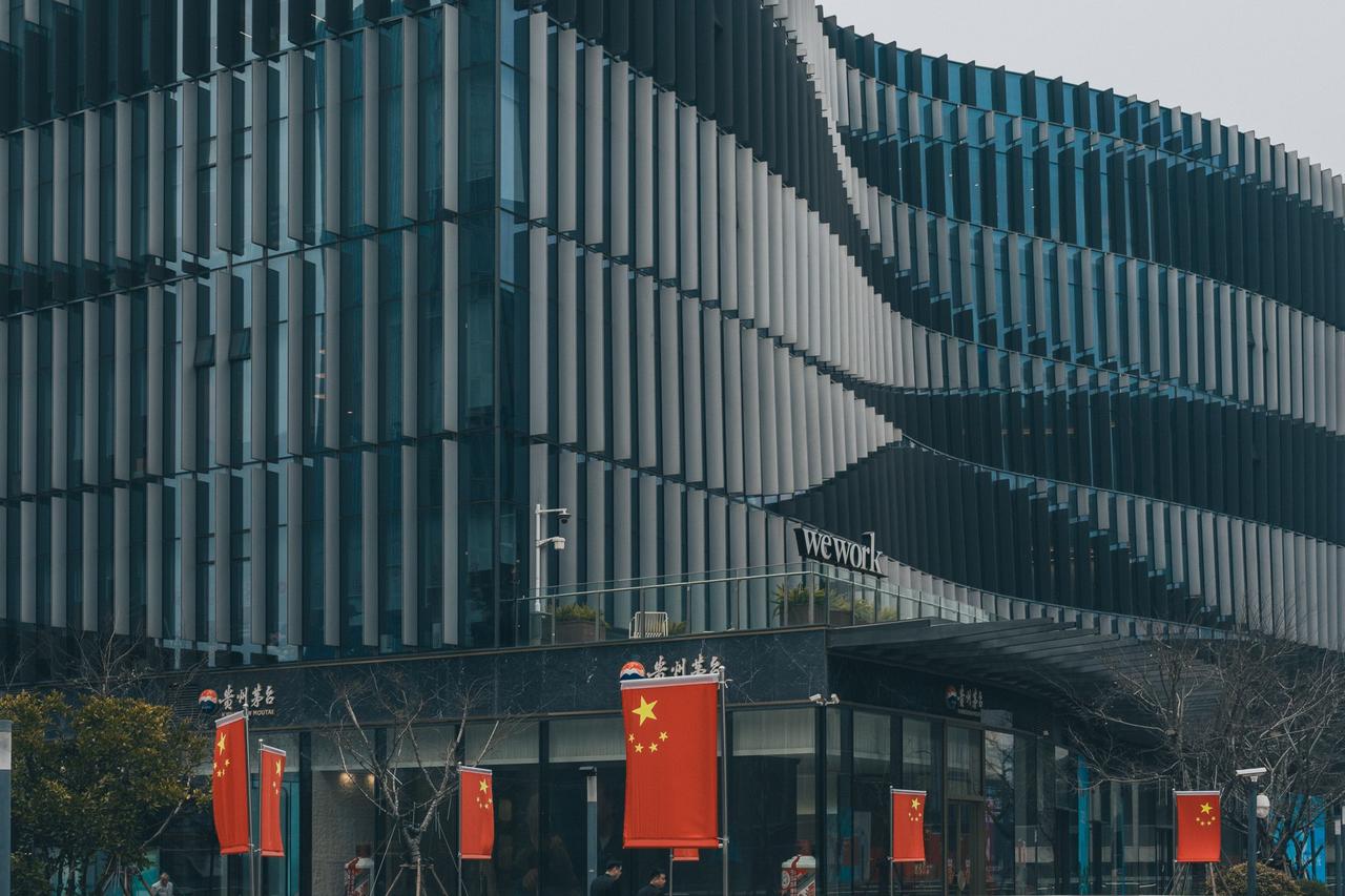 Contemporary architectural building with Chinese flags displayed prominently.