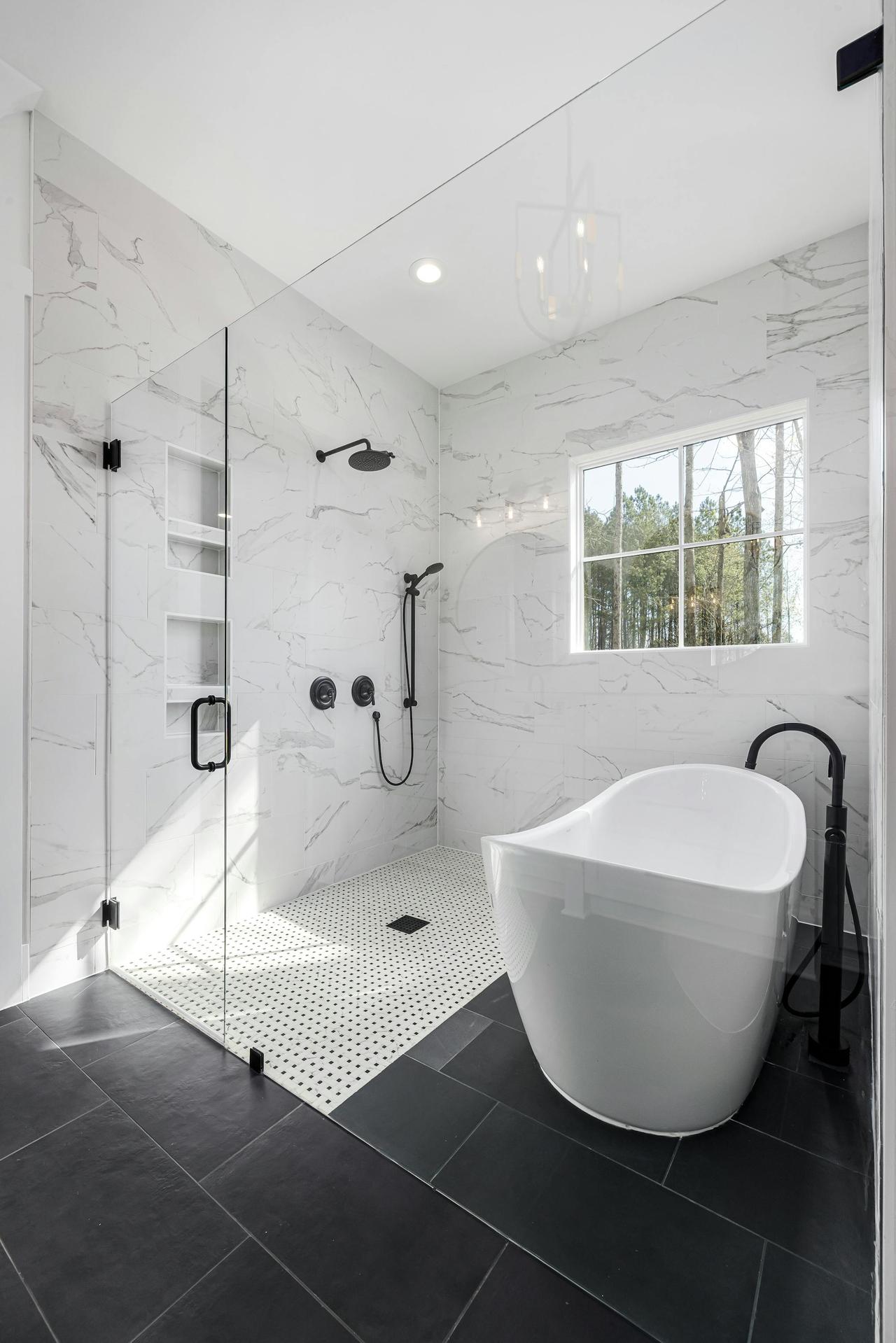 Sleek white bathroom with freestanding tub, glass shower, and natural lighting.