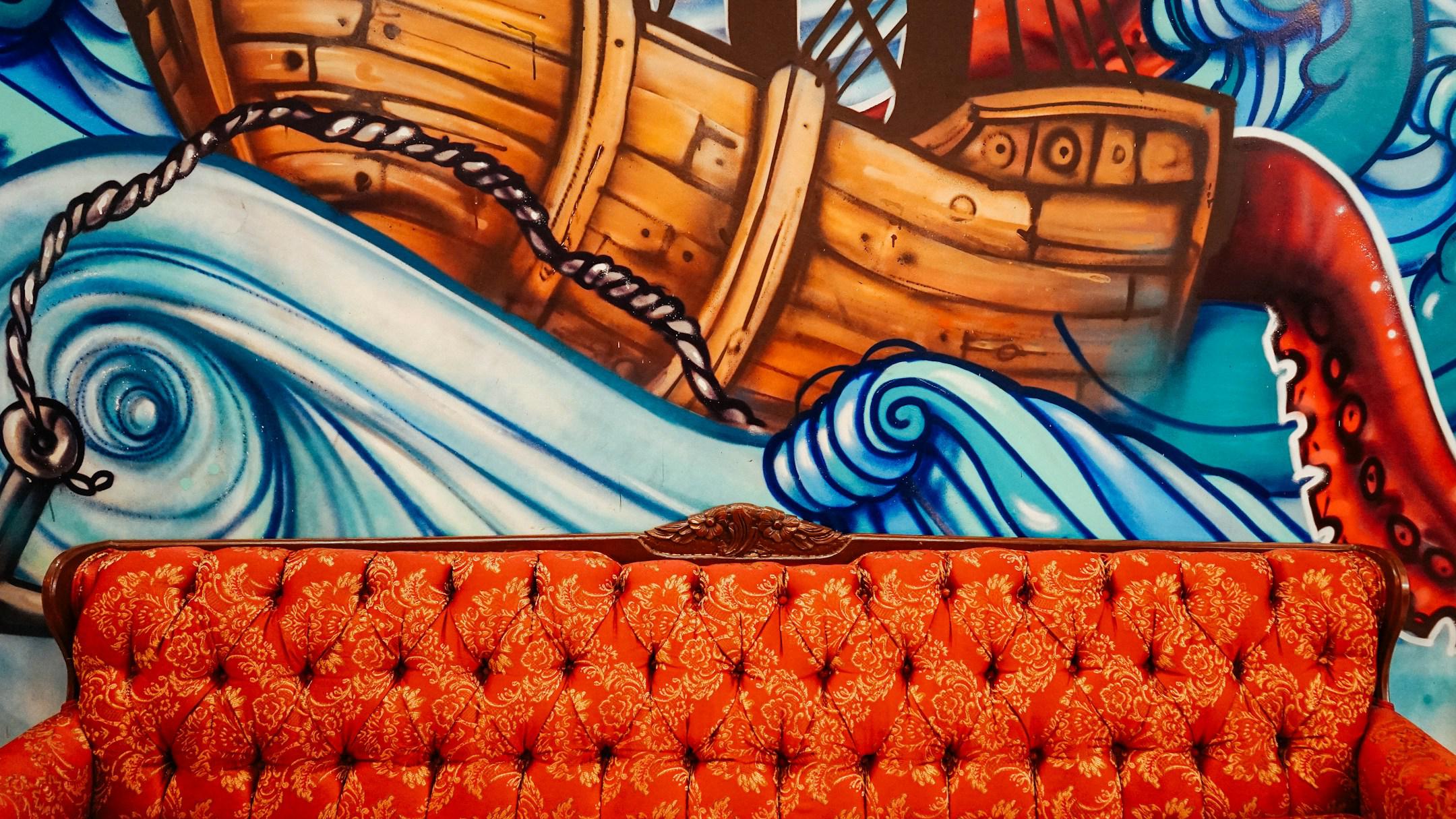 Couch in front of boat mural