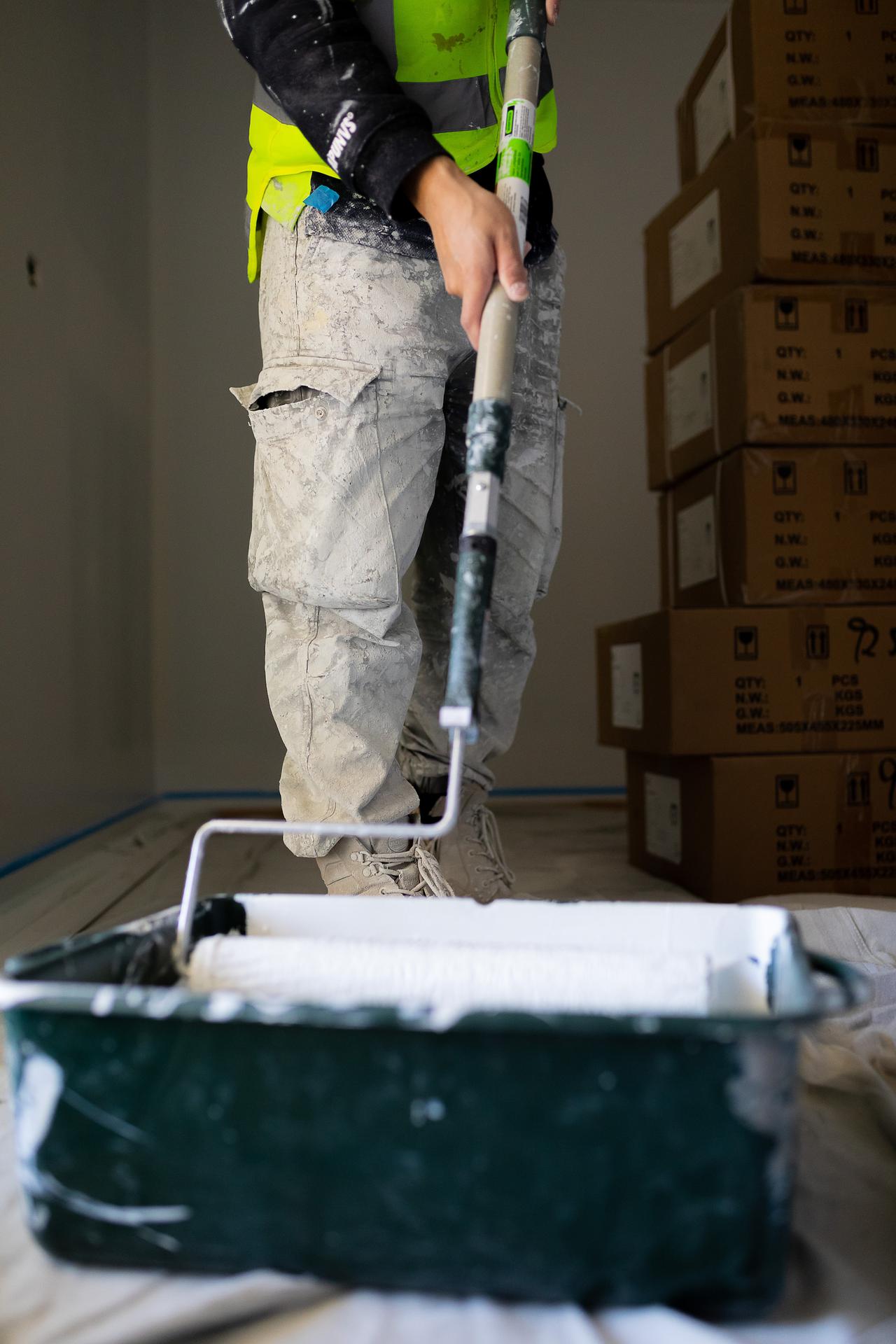 a painter applying more paint to his roller