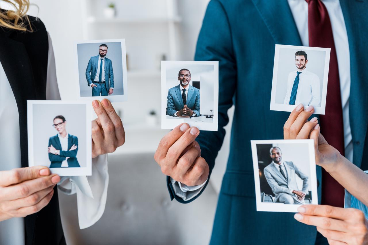 cropped-view-of-recruiters-touching-photos-while-s-2024-11-17-19-05-14-utc.jpg