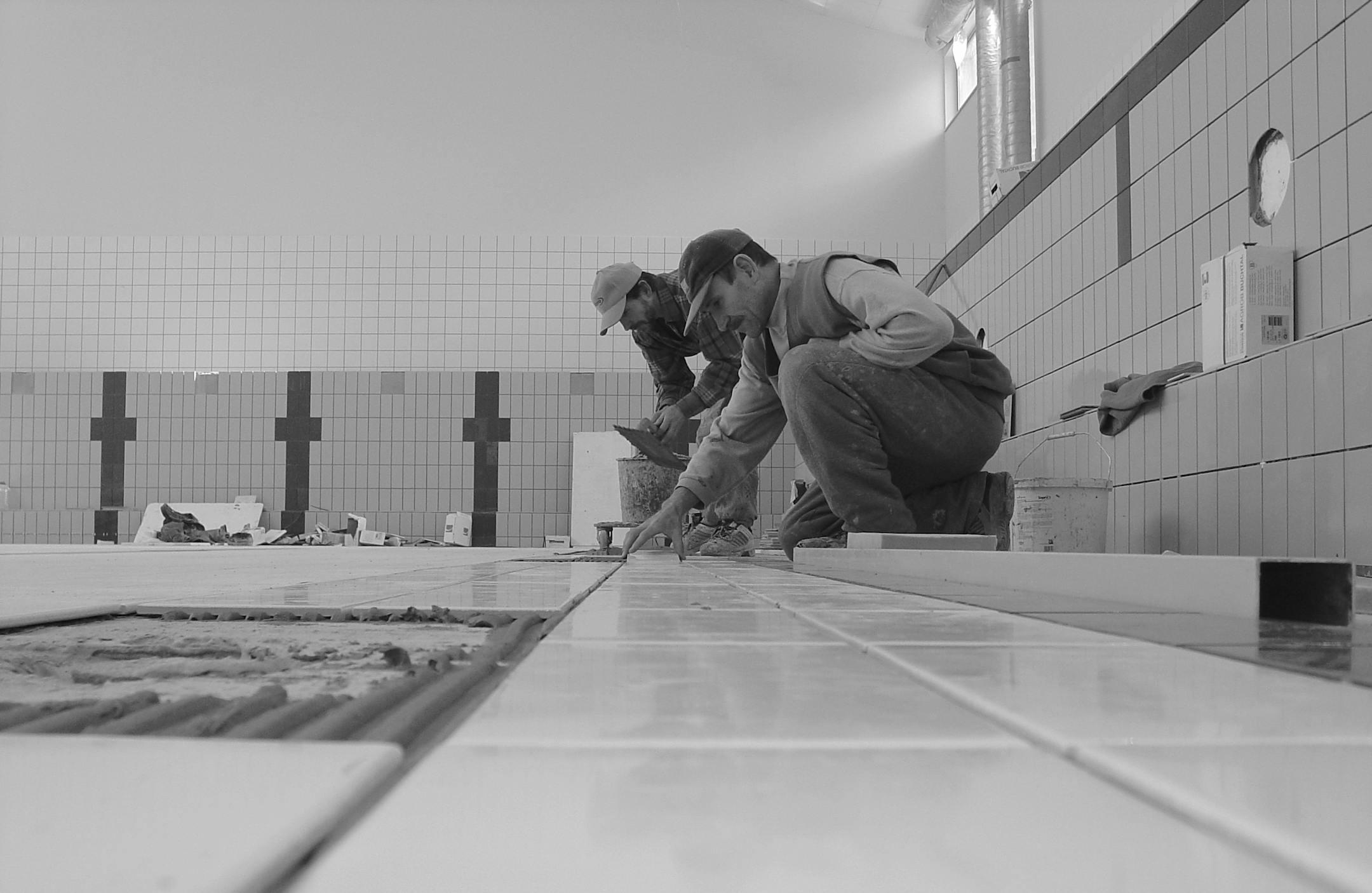Professional workers tiling a bathroom interior, showcasing expertise in construction.