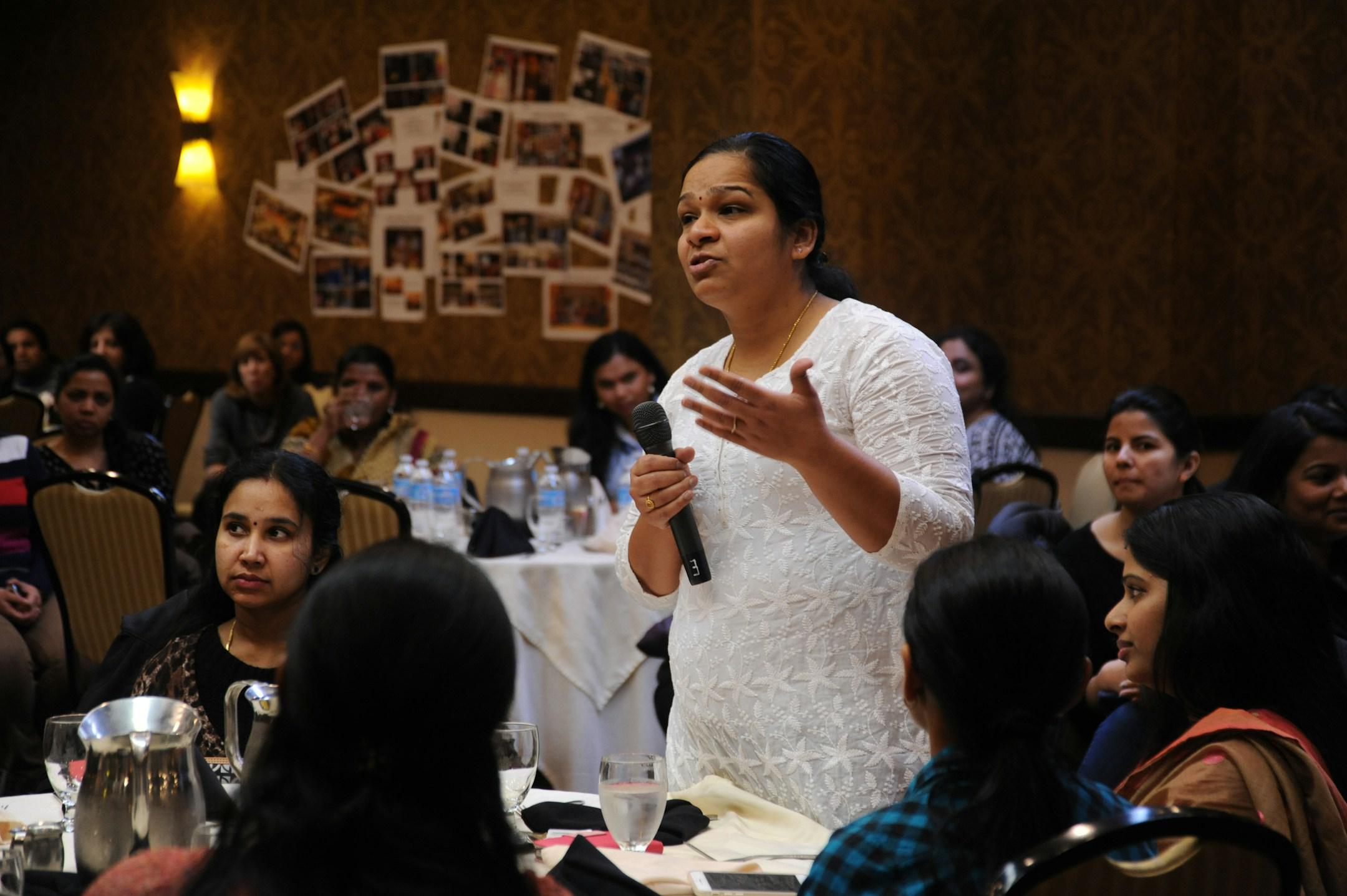 A woman advises the CEO, (out of frame), while he fields questions from the floor, A Celebration of Woman’s Day, Seattle Region, Bellevue, Washington, USA. All the women shown work in high tech as consultants in the US. They are the best and brightest from universities in India. They remain concerned about children in general but specifically girls in India and the rest of the developing world and aspire to help them. A sub-section of technology workers, many of these women are in the US on H1-B Visas.

dro