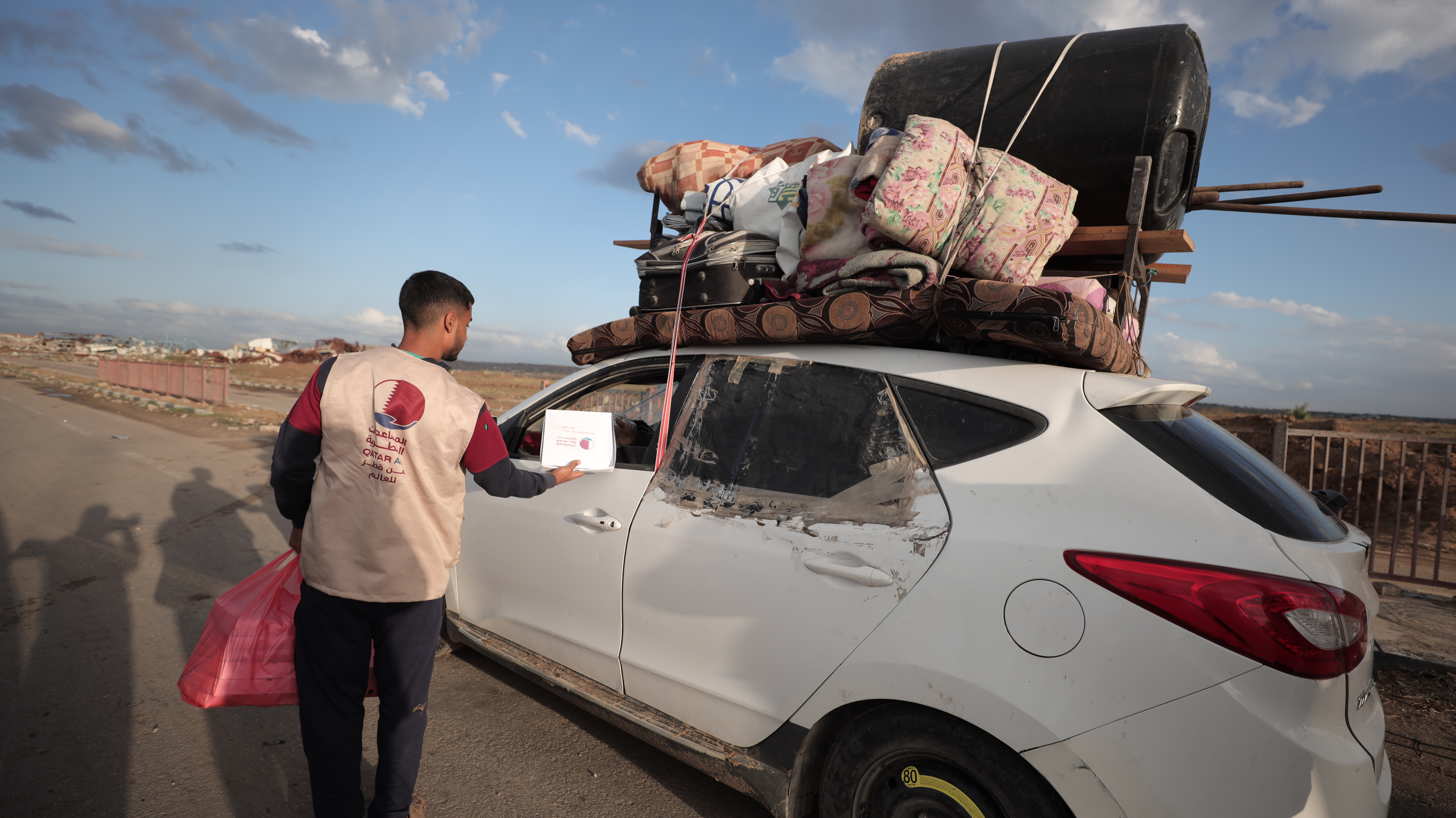 Man giving food to displaced people in their car