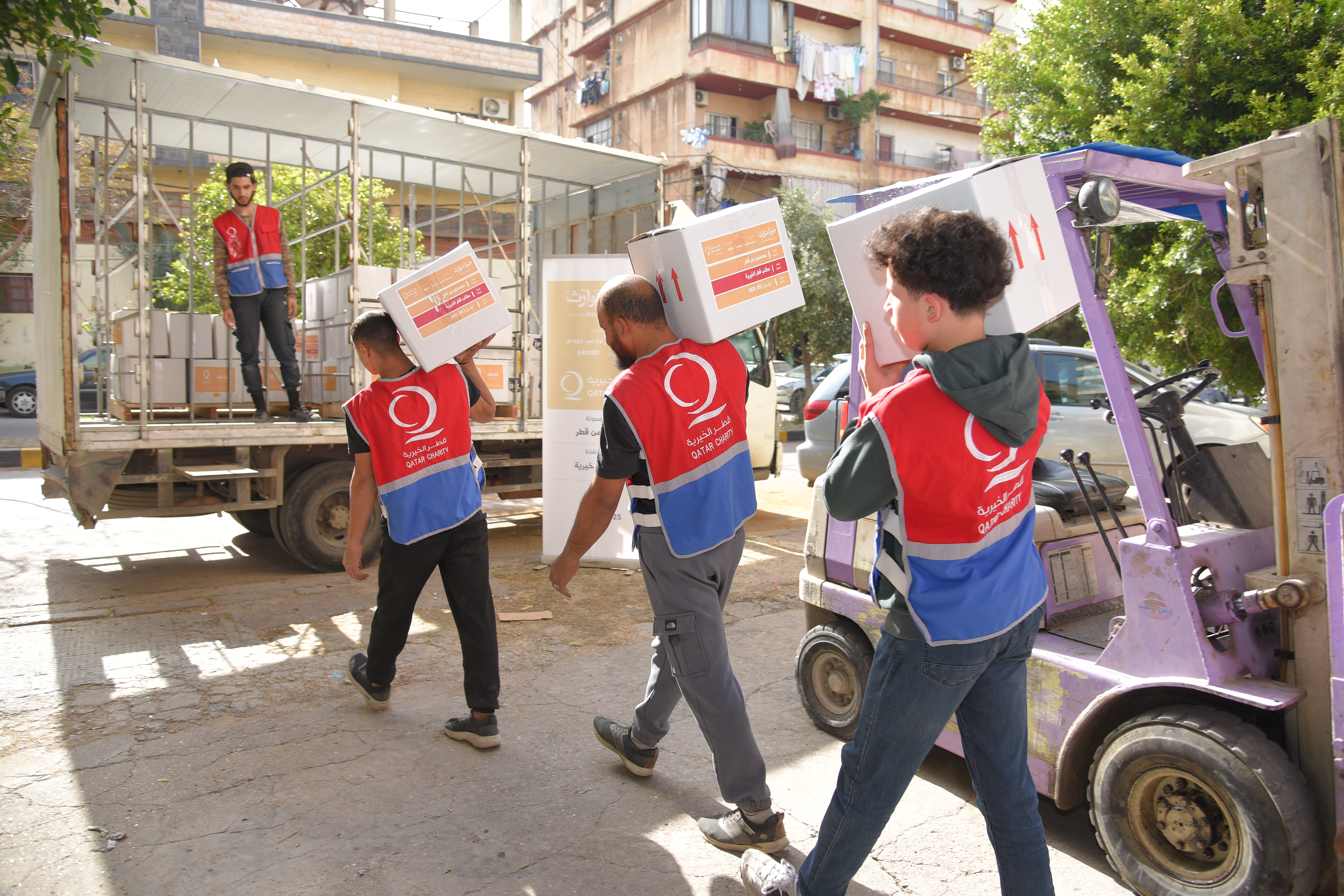 Men carrying food parcel boxes to load into truck