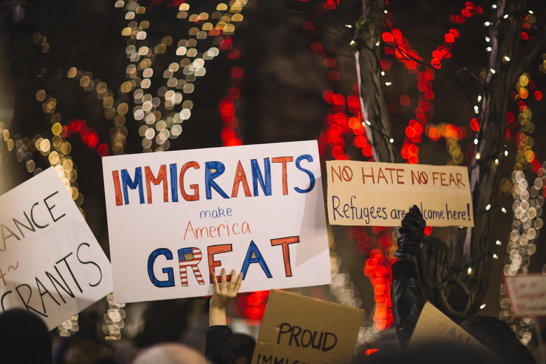 Image of a sign saying immigrants make america great for people applying for political asylum status.