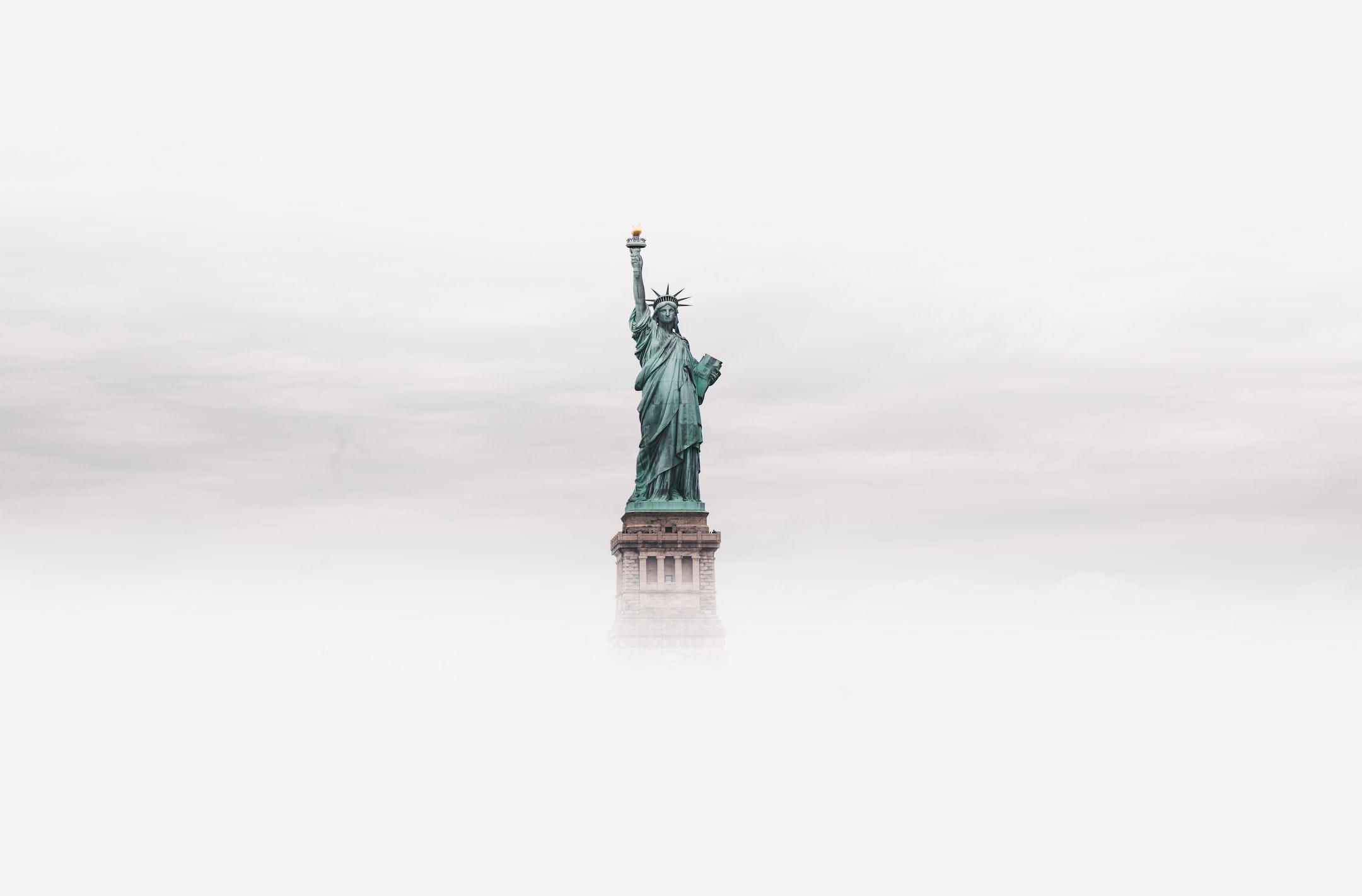 Image of the statue of liberty rising through fog, the same way an immigration attorney in Florida can help.