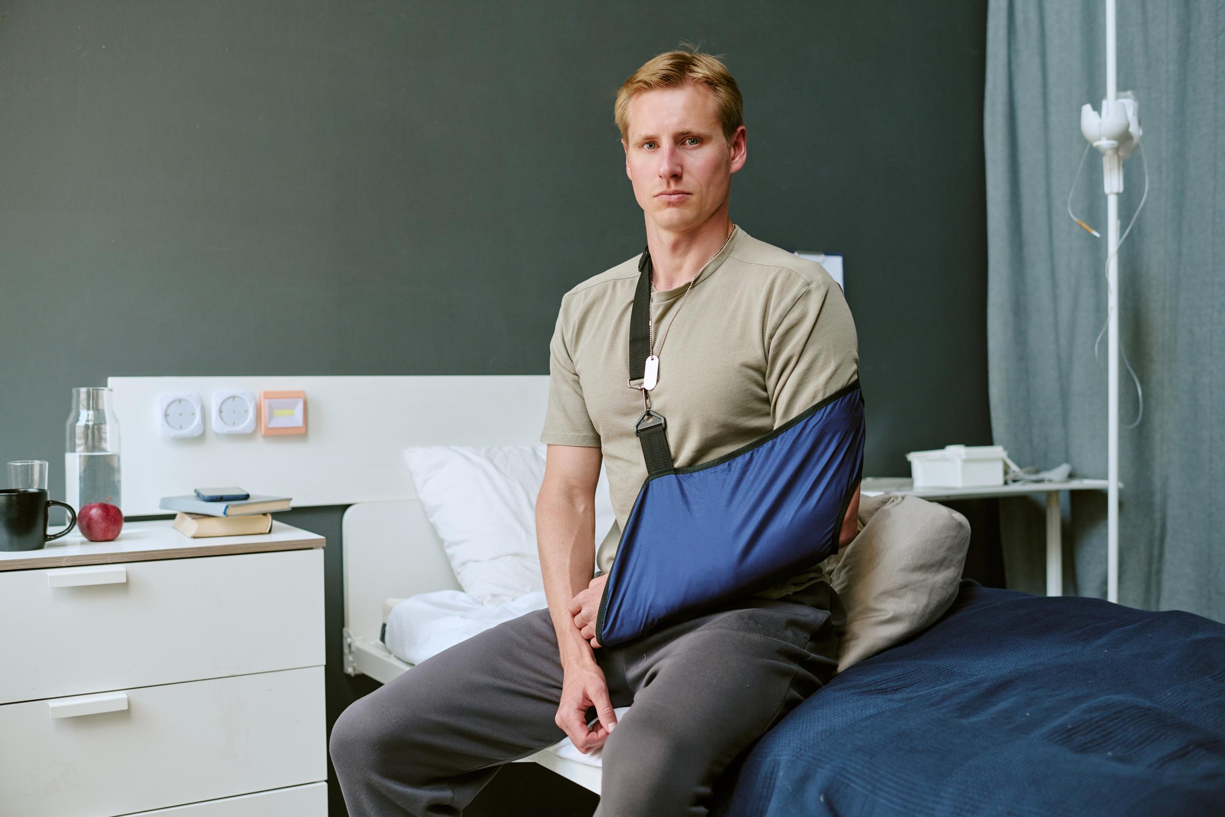 injured-man-with-arm-sling-sitting-on-hospital-bed-2026-09-25-05-45-03-utc.jpg