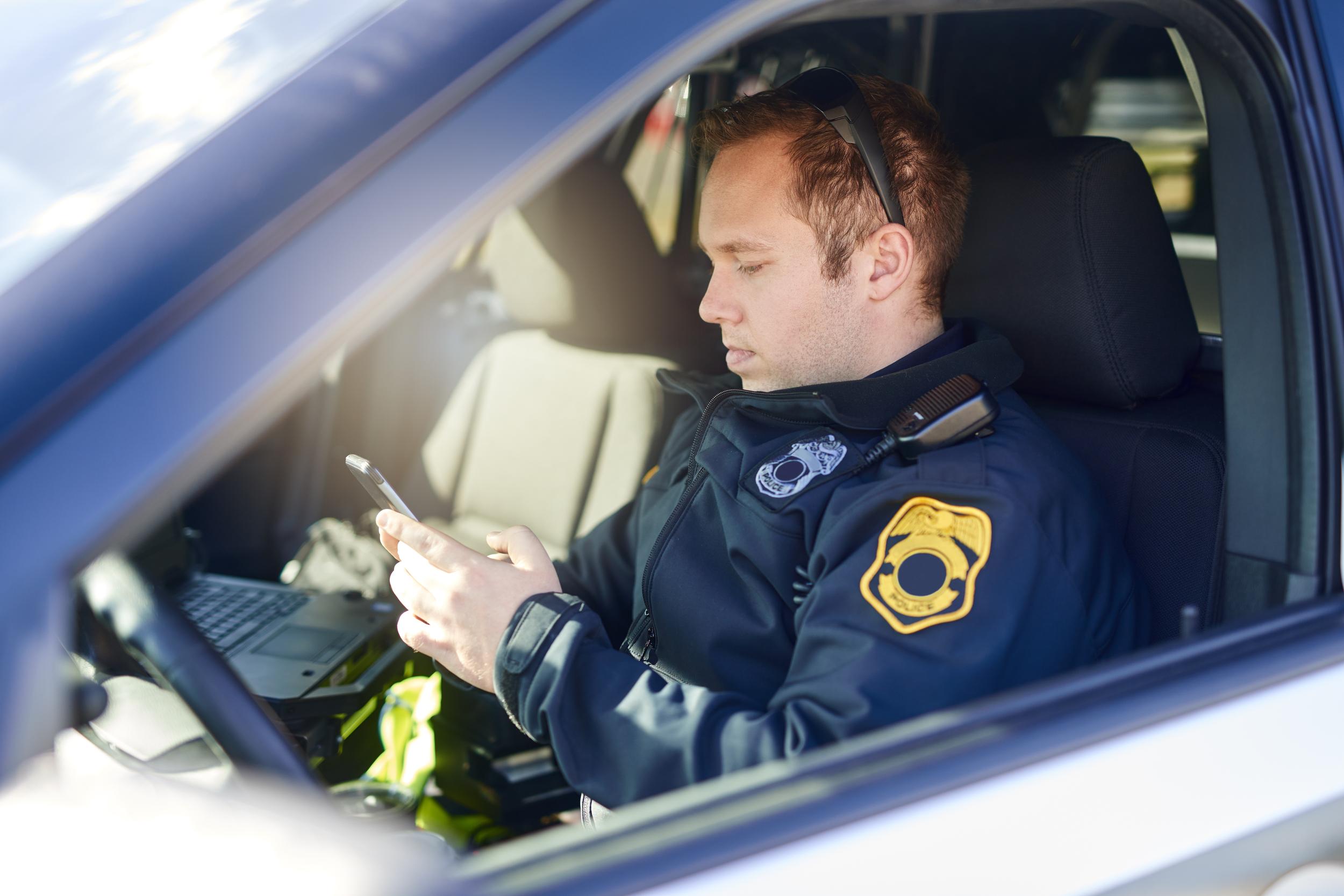 man-using-cellphone-in-car-with-laptop-2026-09-24-12-58-15-utc.jpg