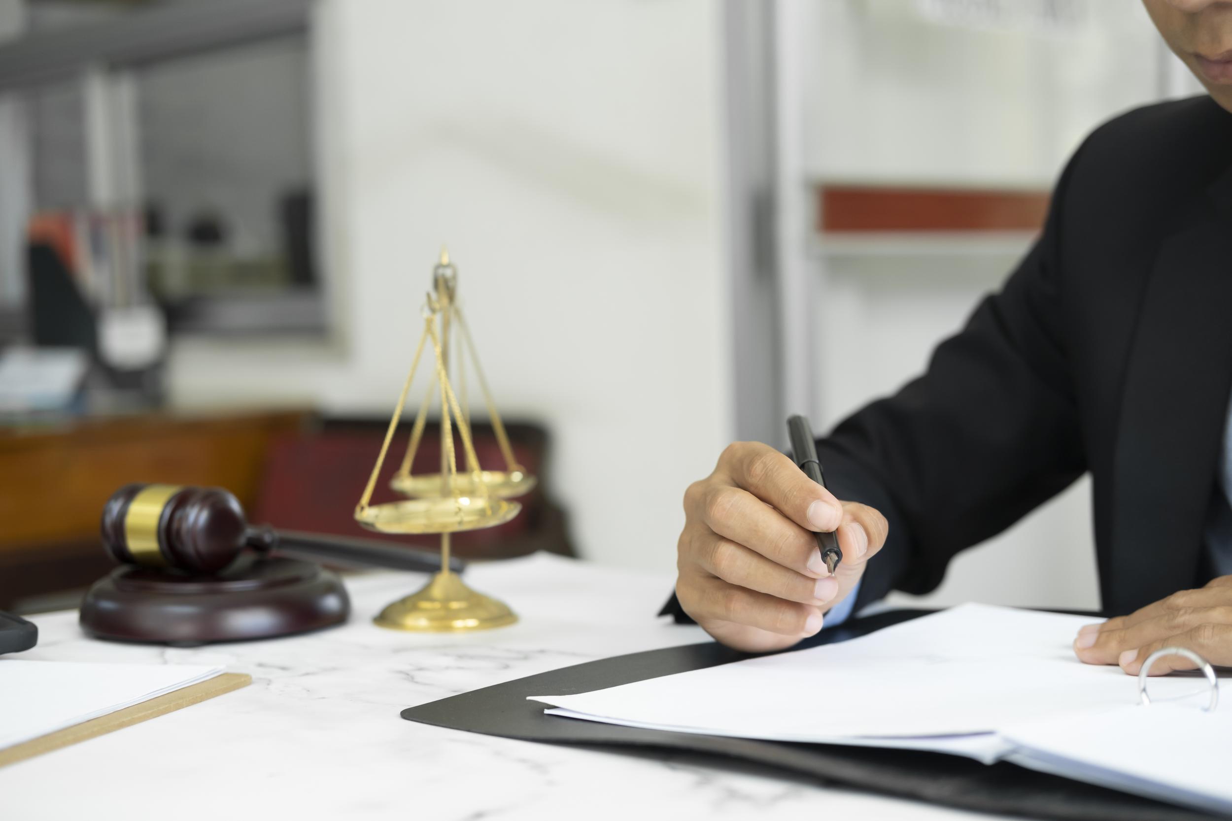 attorney-signing-documents-in-office-with-scales-2026-09-22-03-25-50-utc.jpg