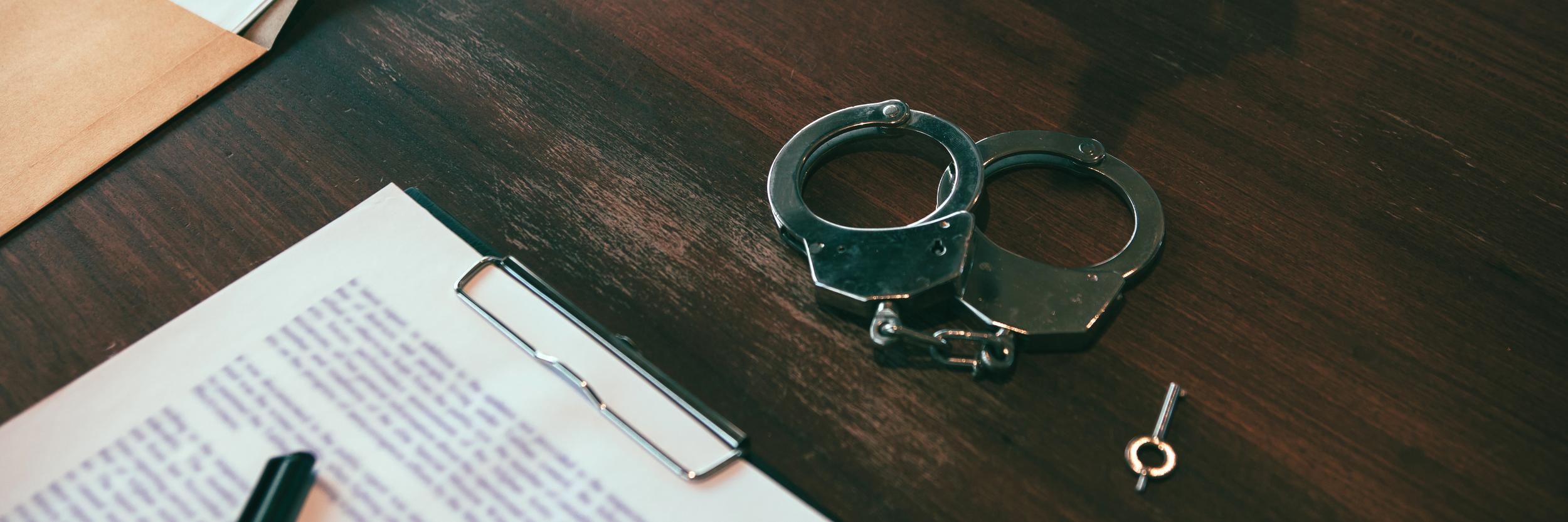 handcuffs-key-and-documents-on-wooden-desk-2026-09-23-02-20-14-utc.jpg