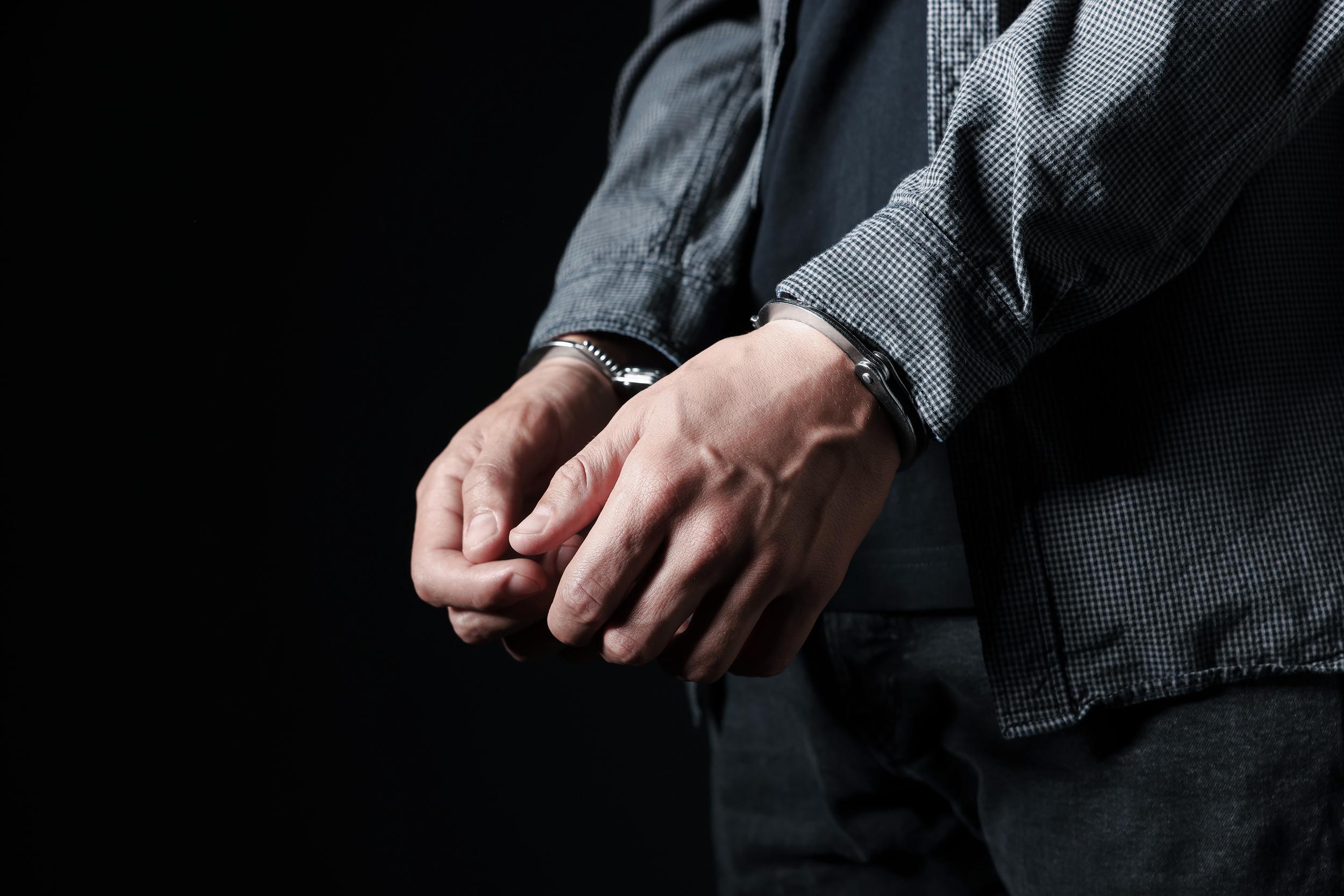 close-up-of-man-in-handcuffs-against-a-black-backg-2026-09-25-04-37-05-utc.jpg