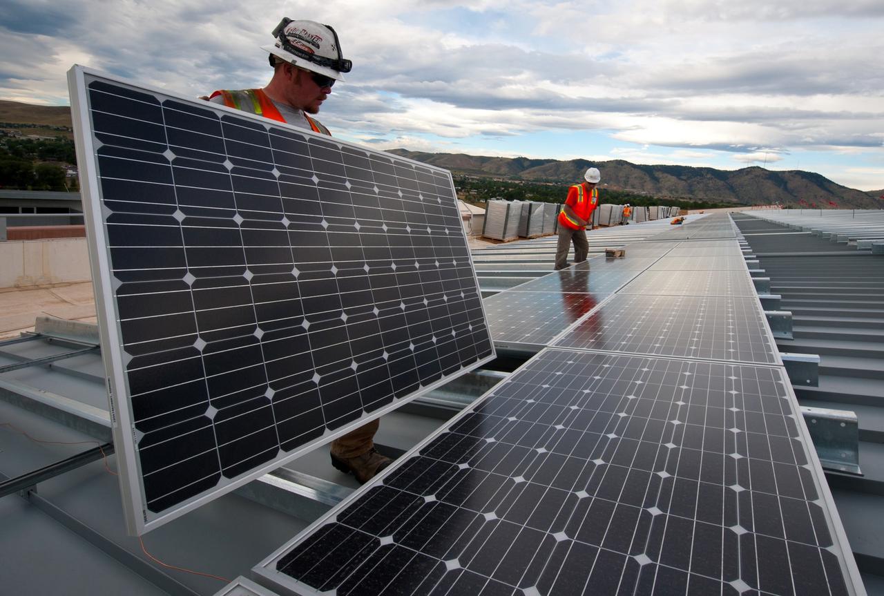 Solar Industry At Work. Brian Lawson and Kenesaw Burwell work on panels that the Energy Department is using to leverage a Power Purchase Agreement with Sun Edison and Xcel Energy.