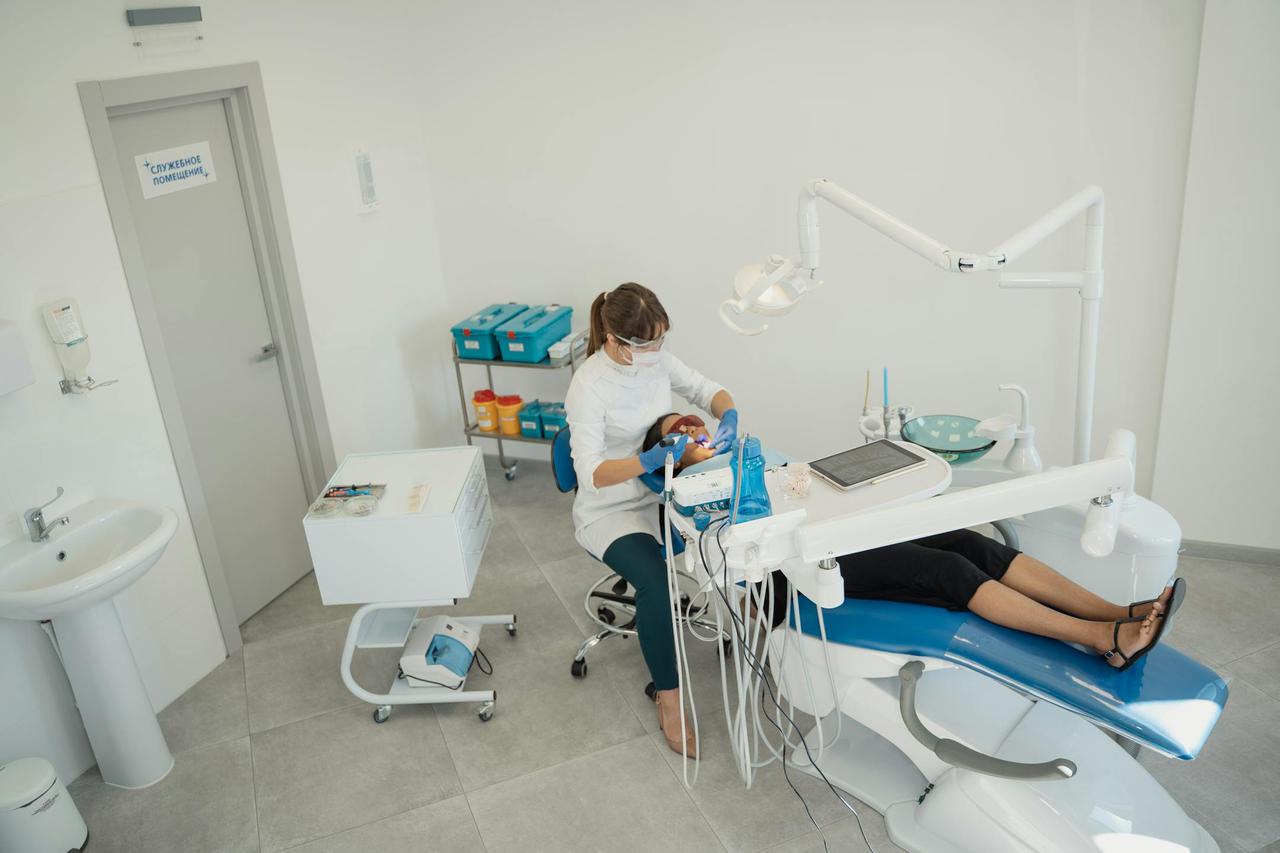 A dentist performs a checkup on a patient in a well-equipped dental clinic.