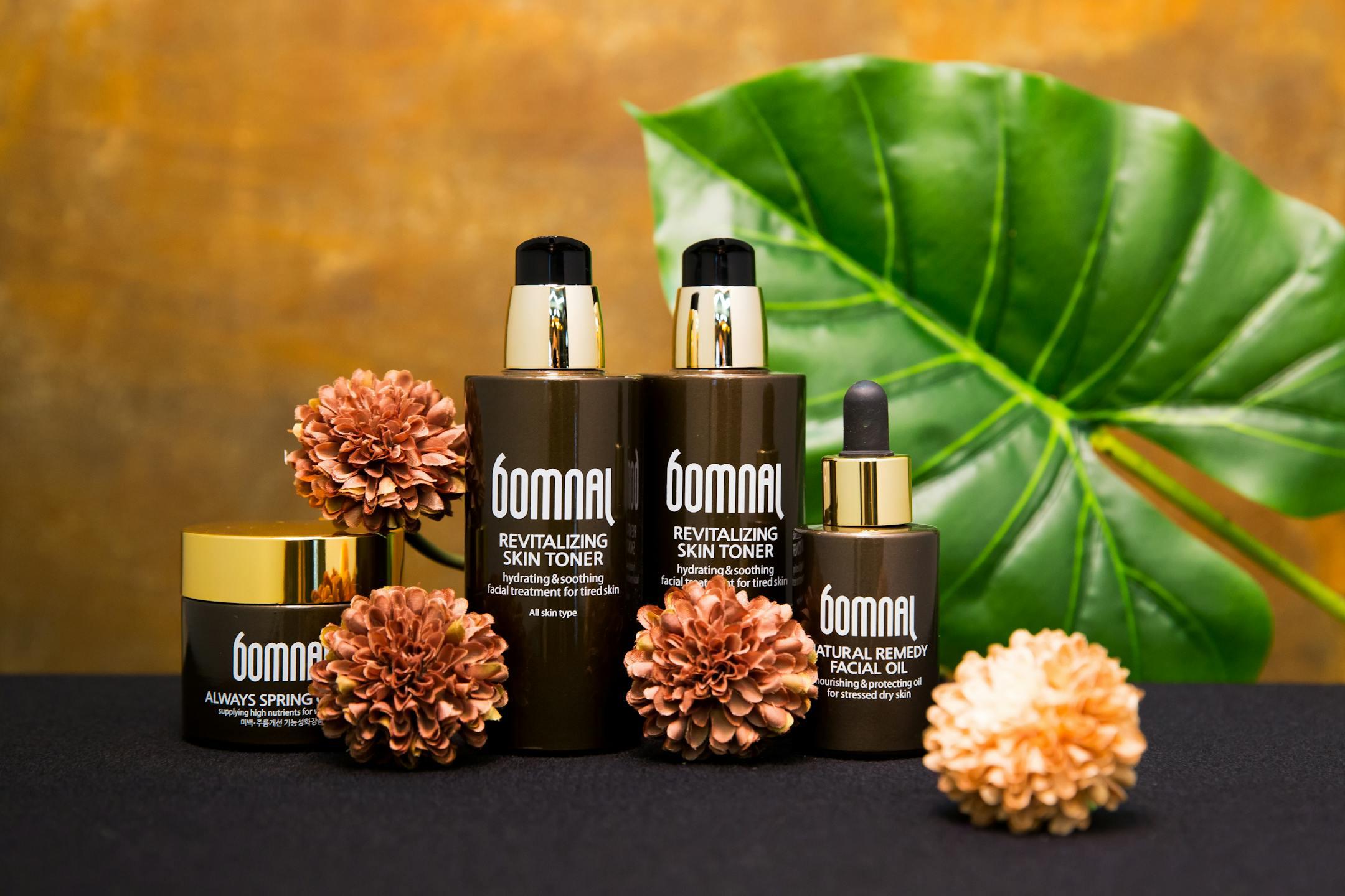 Cosmetic products displayed with flowers and leaves, emphasizing natural beauty care.