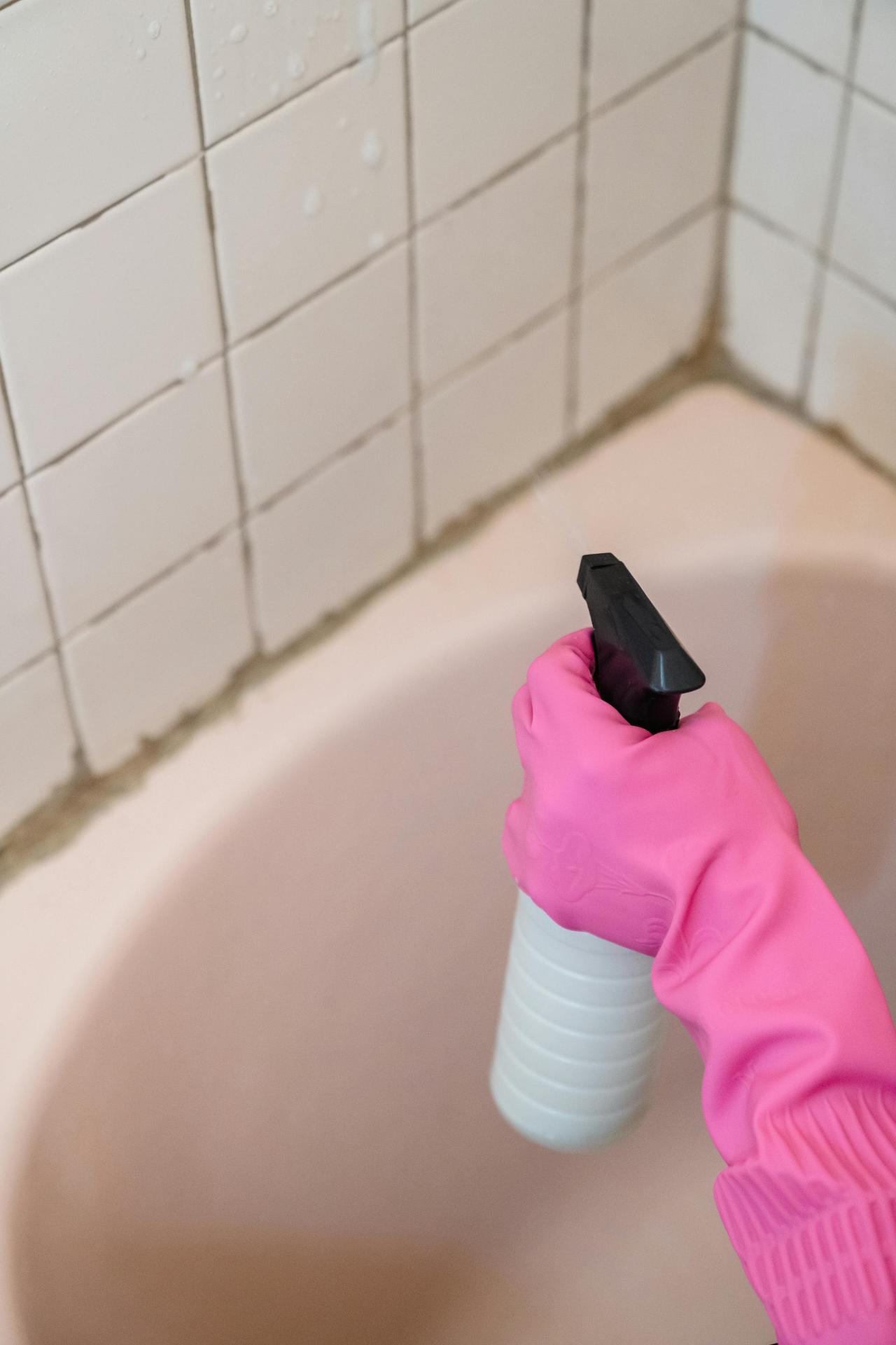 Contact Mystic Cleaning Co. to request your free quote or schedule a cleaning in Conroe, TX. Friendly, professional, and eco-friendly — we clean so you can breathe easier.A person wearing a pink glove cleans bathroom tiles with a spray bottle.