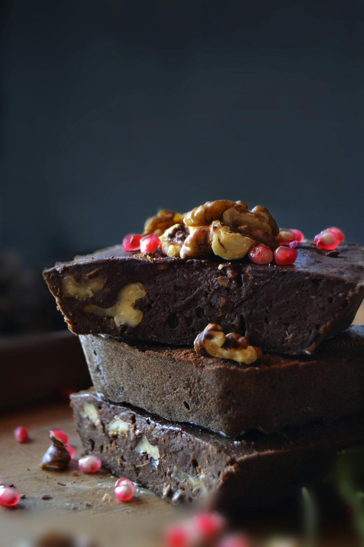 Delicious stacked chocolate brownies topped with walnuts and berries for a rich dessert experience.