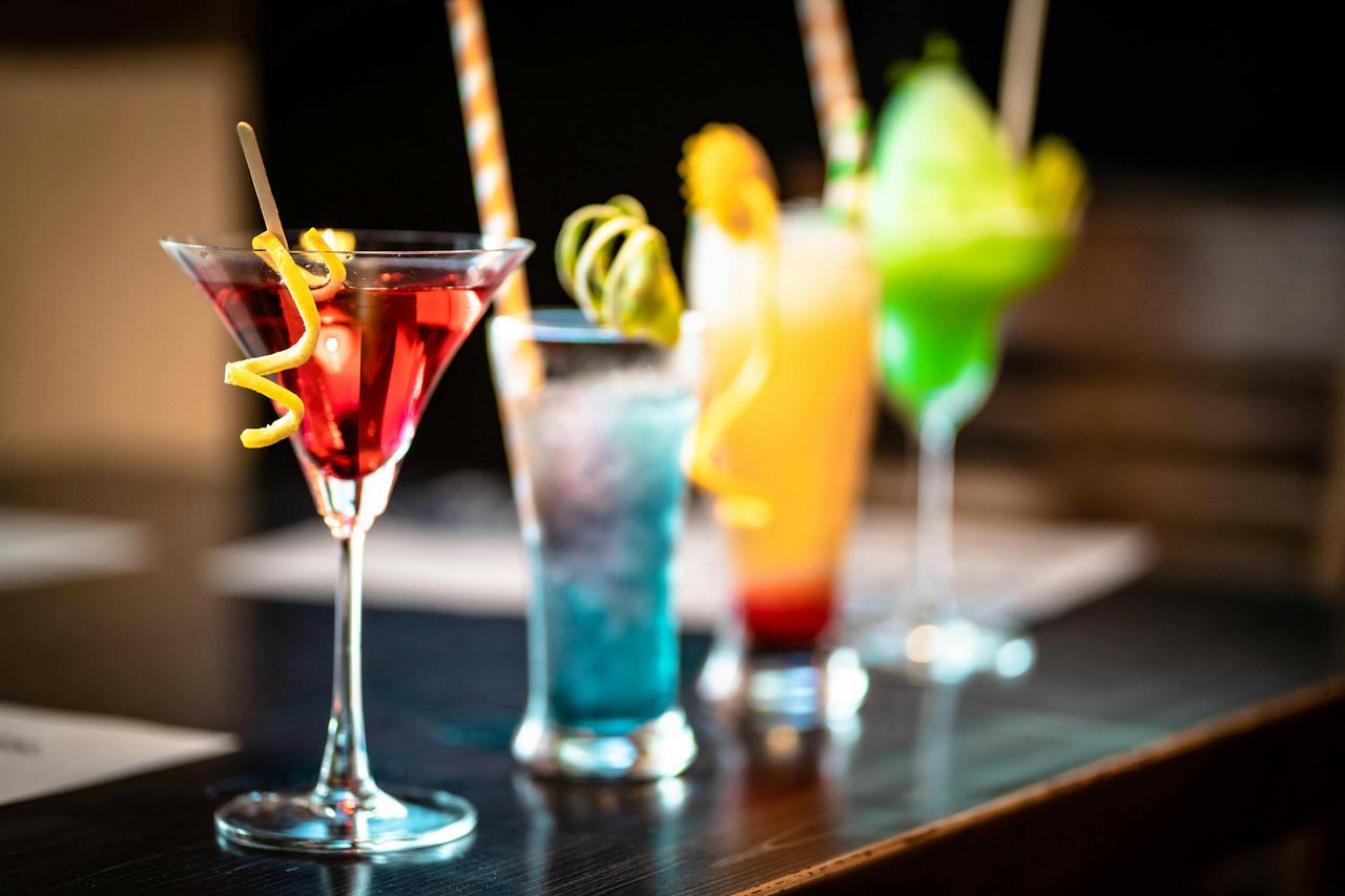 A colorful array of cocktails with fruity garnishes, perfect for a lively bar setting.