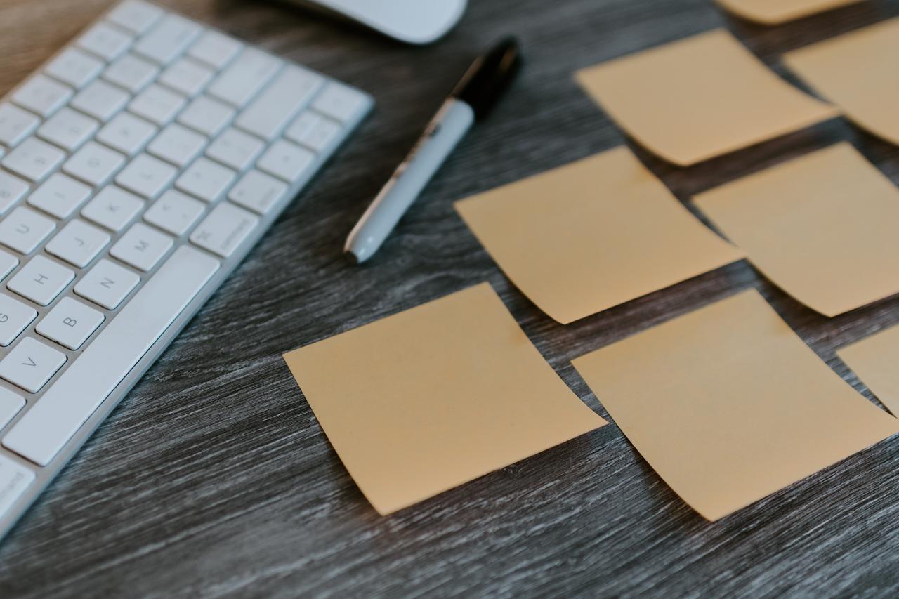 Group of blank sticky notes on a desk with a sharpie marker