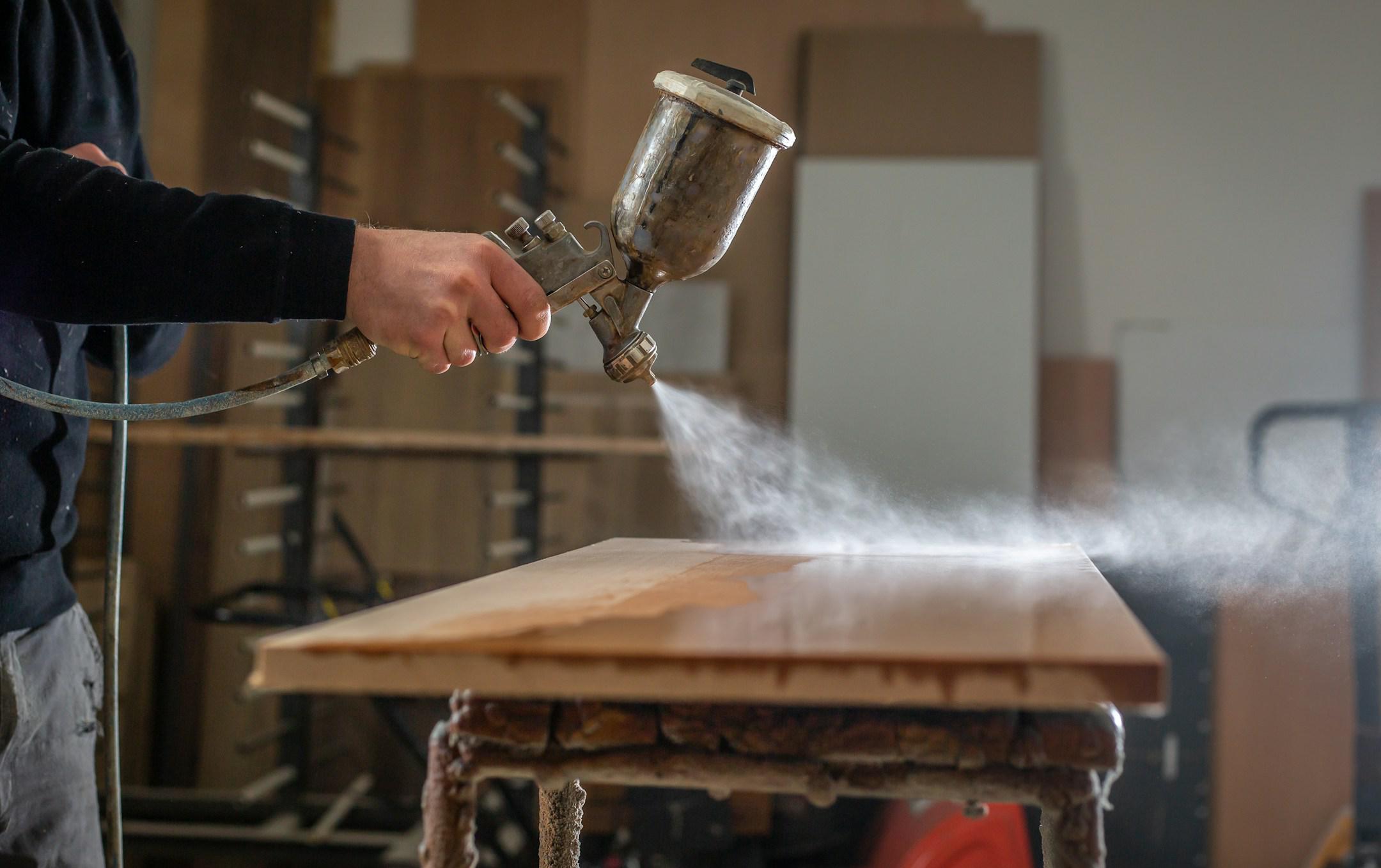 Staining wood with white spray gun,  application of flame retardant ensuring fire protection, airless spraying device, industrial concept