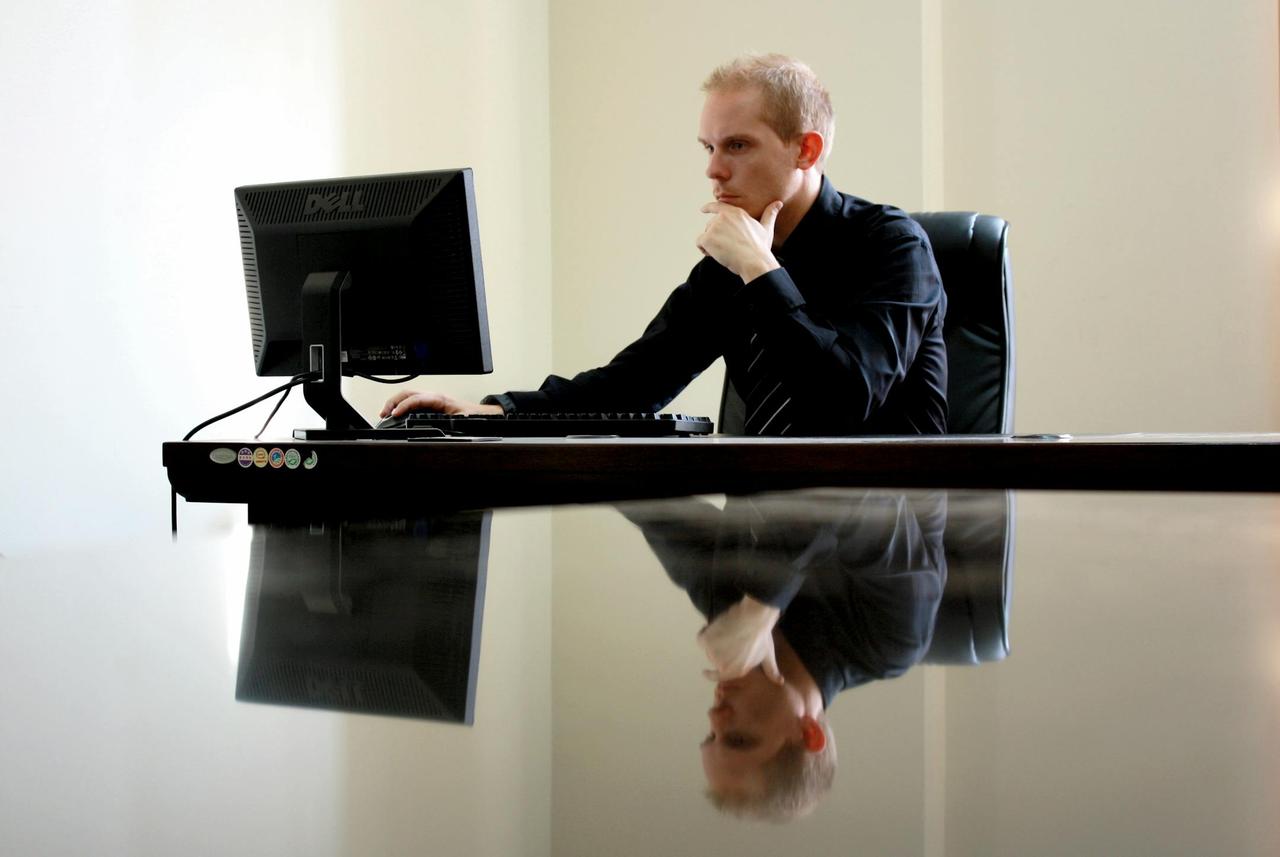 A businessman in deep thought at his desk, reflecting on work tasks.