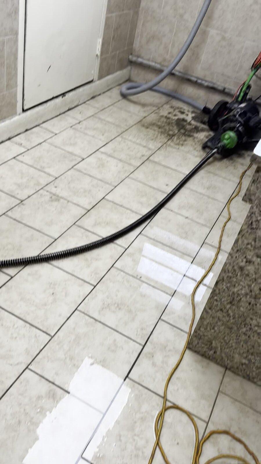 Drain-snaking equipment clearing a Metro Detroit floor drain