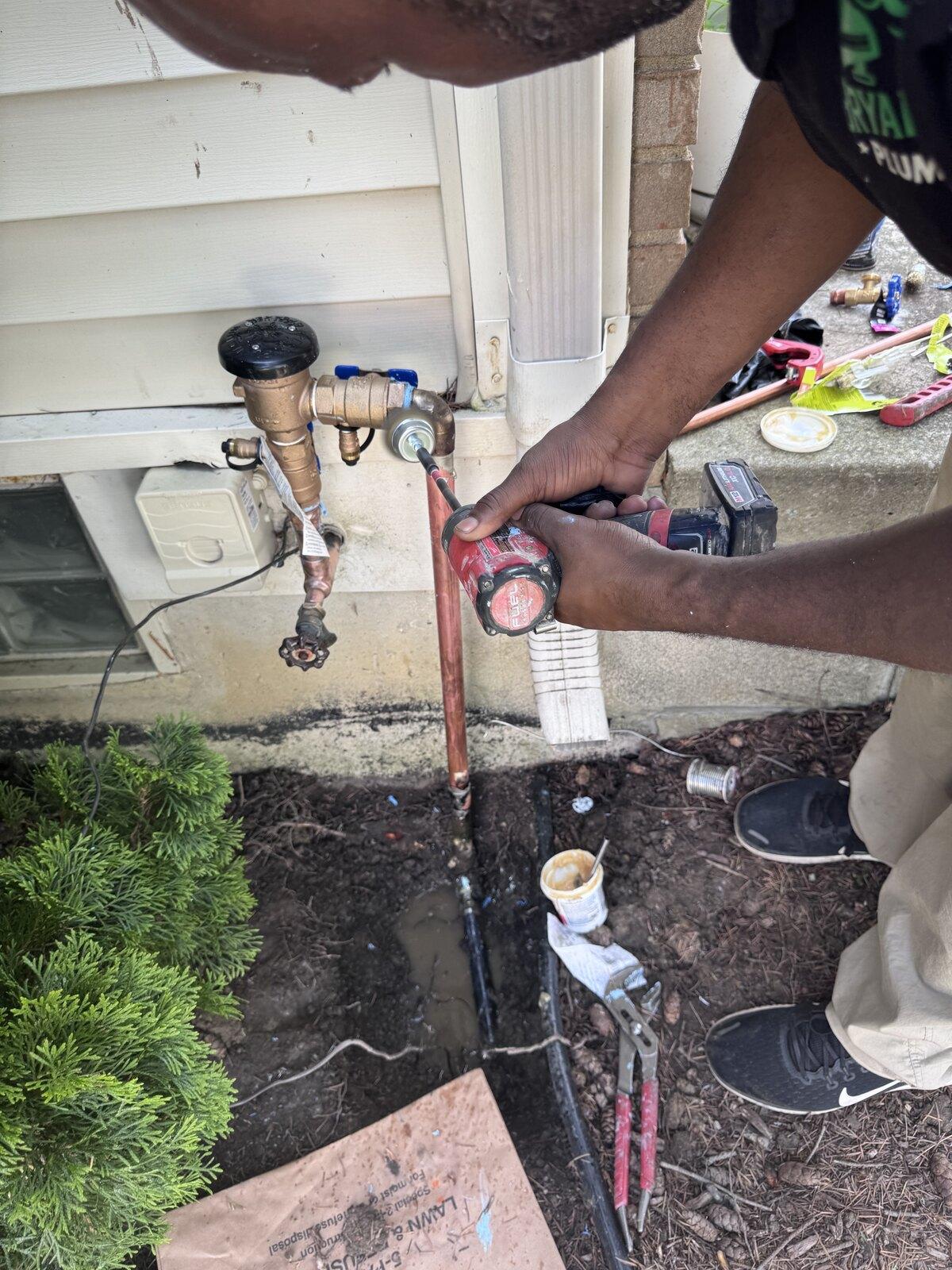 Bryant & Sons technician installing an exterior backflow preventer