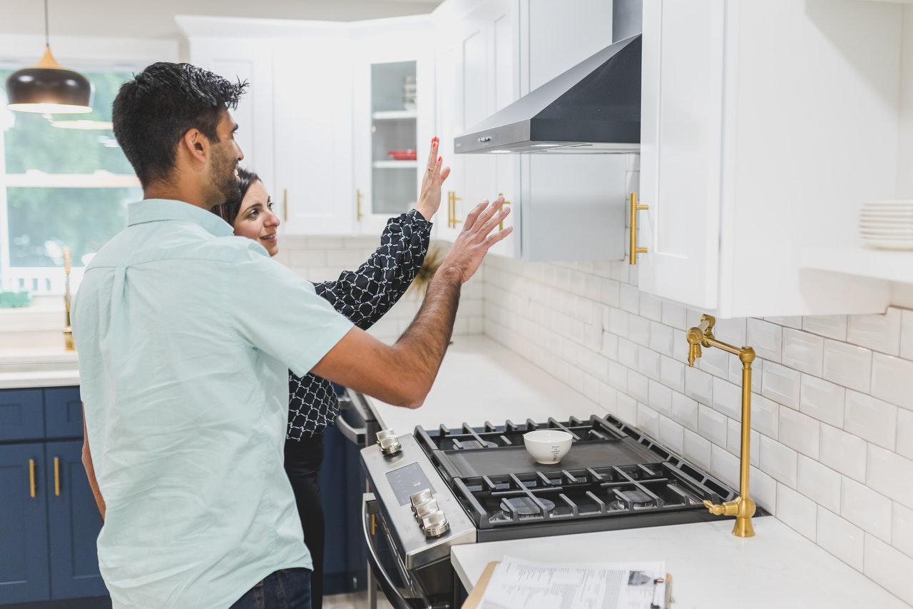 Image of a couple looking at the hood over their range, happy with the results of their home renovation in Chicago.