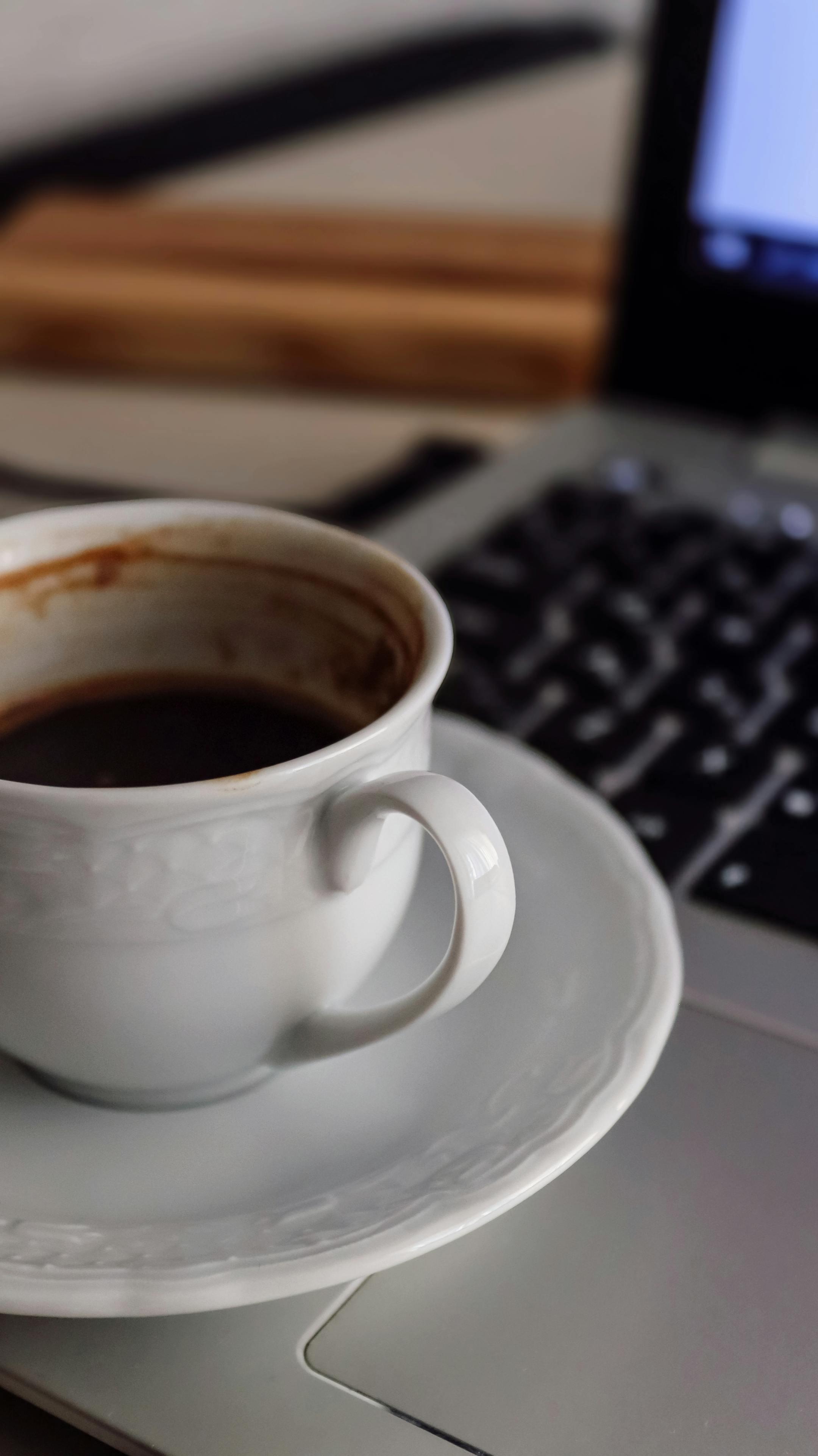 Close-up of a coffee cup on a laptop, ideal for productivity or remote work concepts.