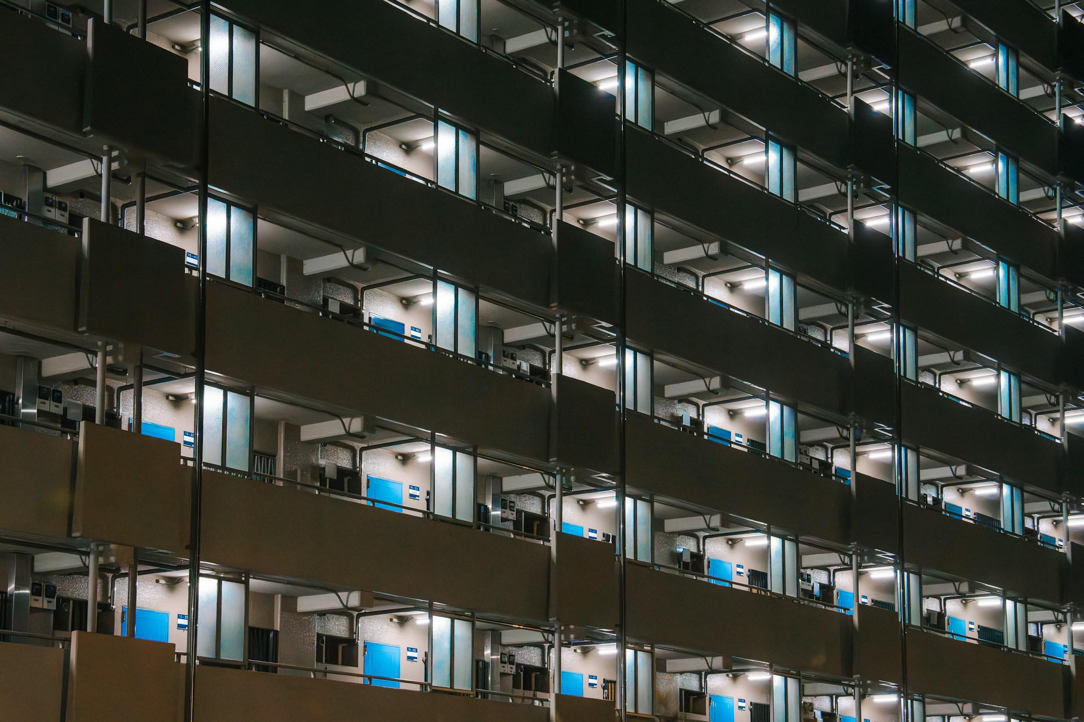 A vast housing complex featuring rows of doors, each painted a striking shade of blue.
