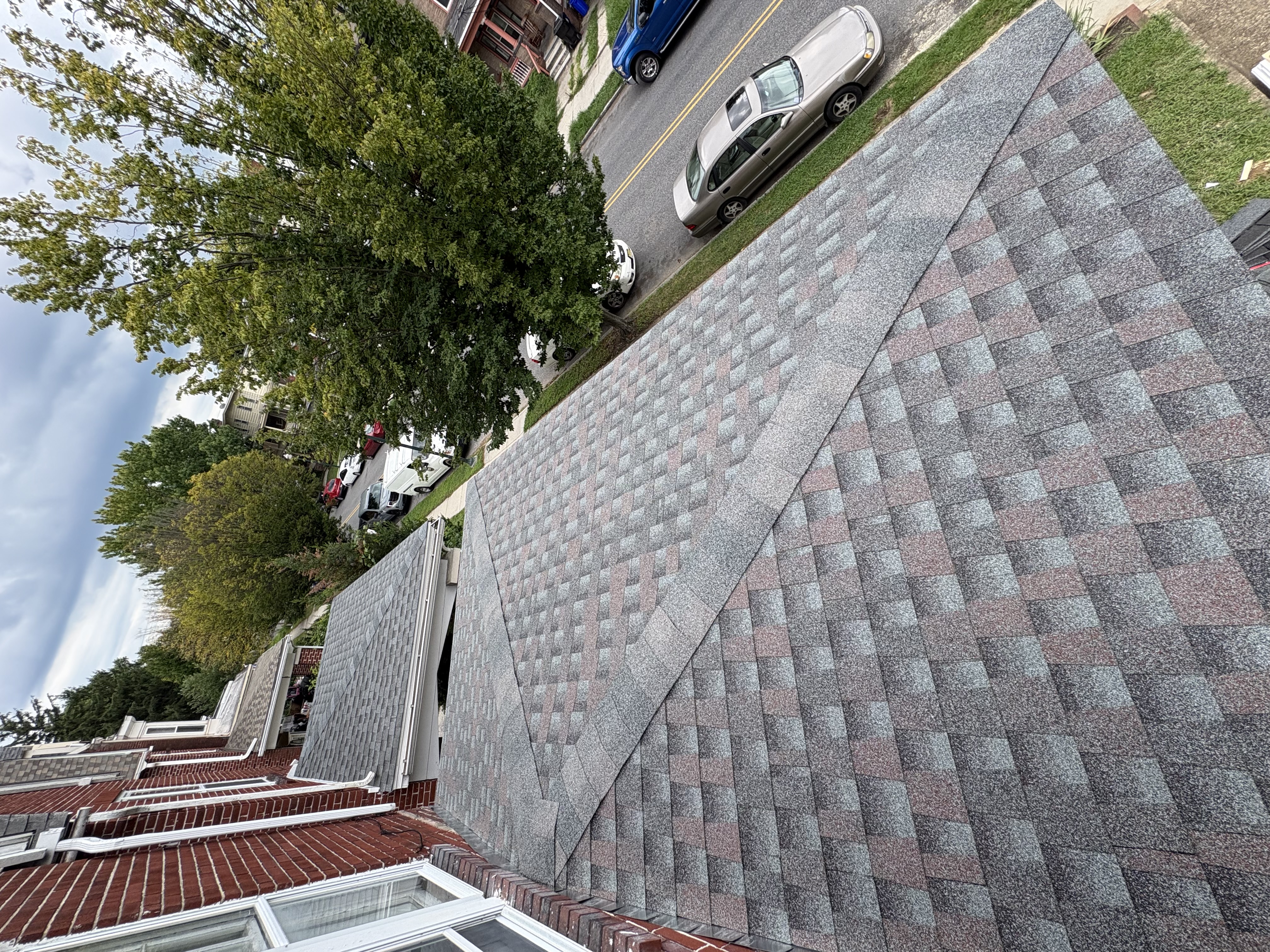 Professional roof replacement showing new asphalt shingles