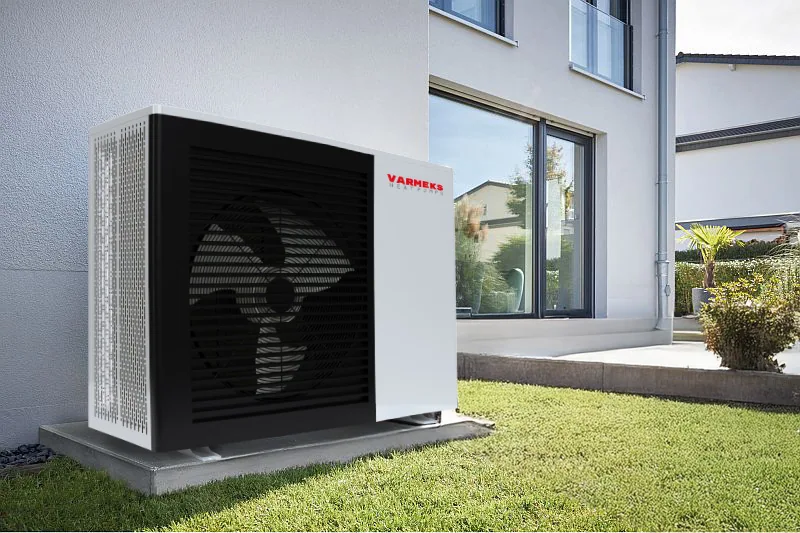 Die Außeneinheit der <strong>Varm Up</strong> Wärmepumpe ist dank ihres leisen und hocheffizienten Betriebs ideal im Garten eines modernen Hauses platziert.