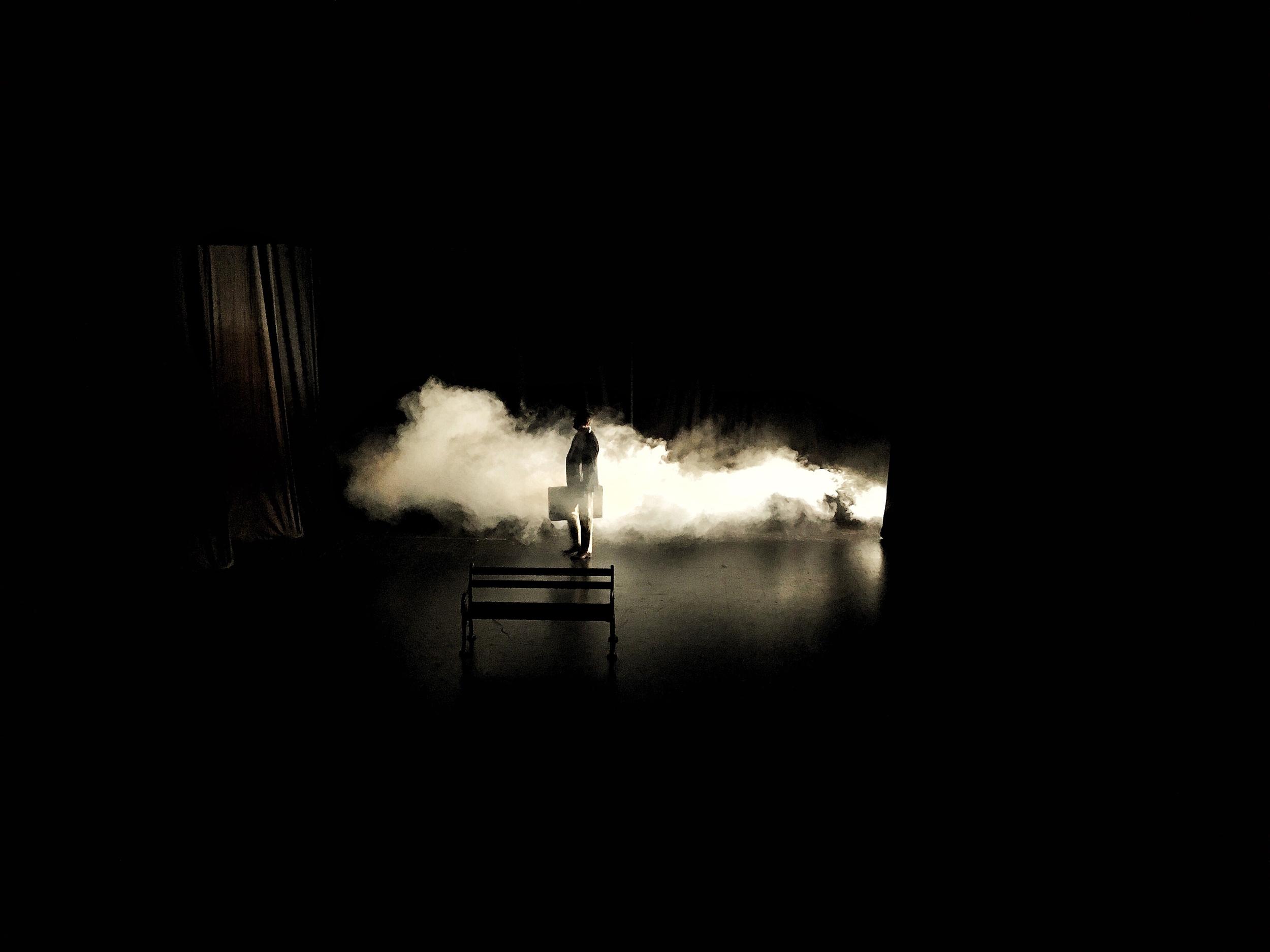 figure-stands-with-briefcase-amidst-stage-smoke-2026-03-13-01-48-11-utc.jpg