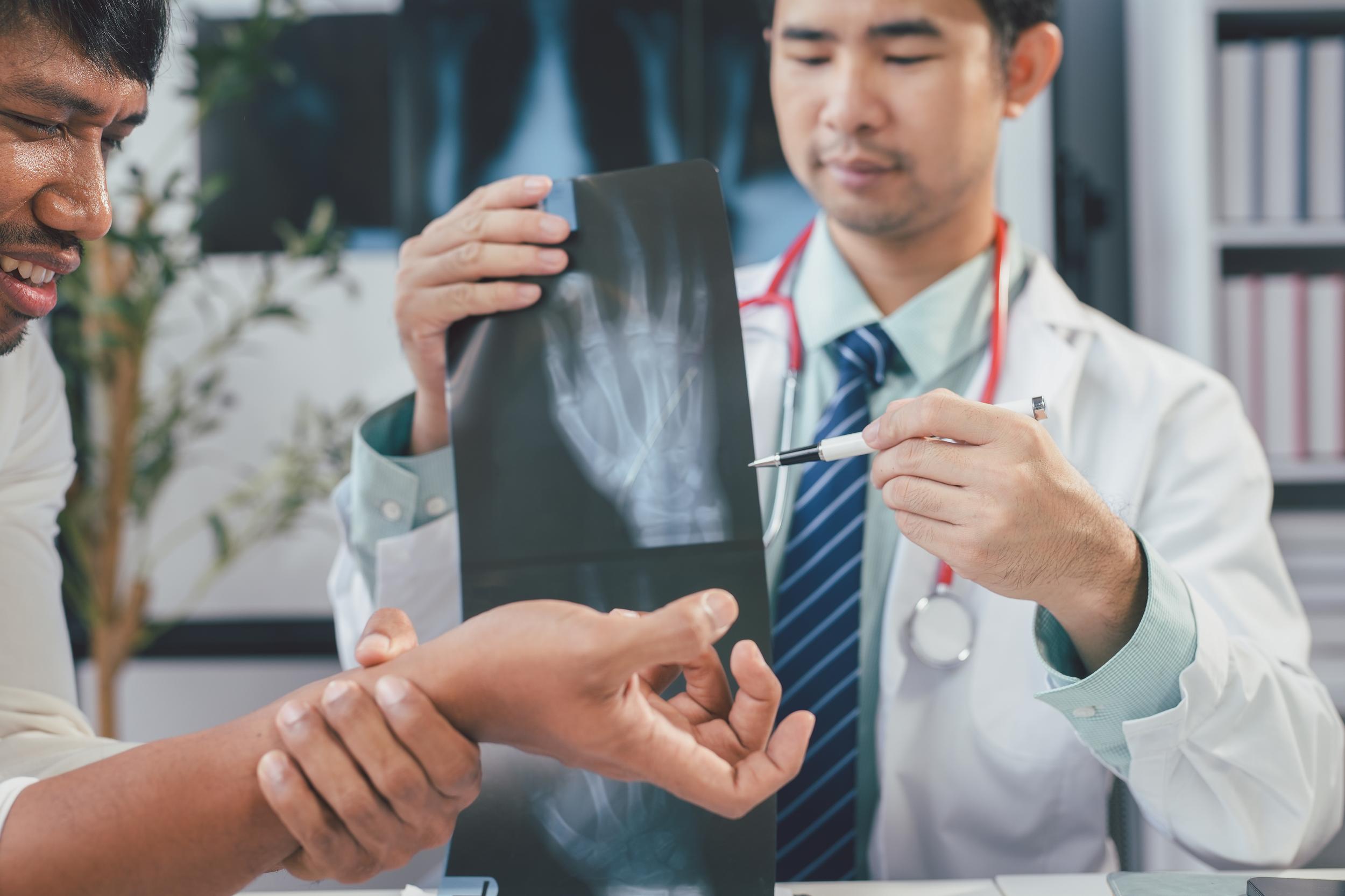 doctor-examining-hand-x-ray-with-patient-in-office-2026-03-19-22-40-08-utc.jpg