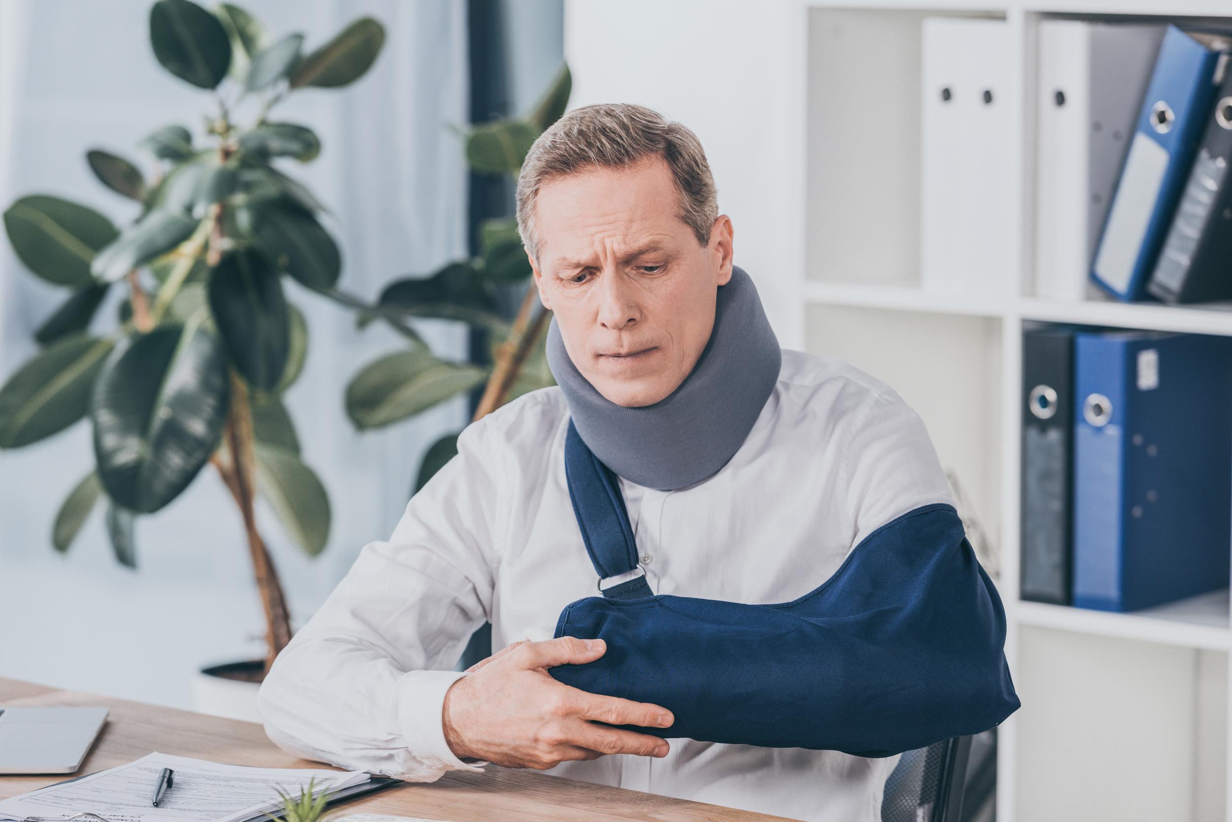 middle-aged-worker-holding-broken-arm-wile-sitting-2026-03-13-01-20-28-utc.jpg