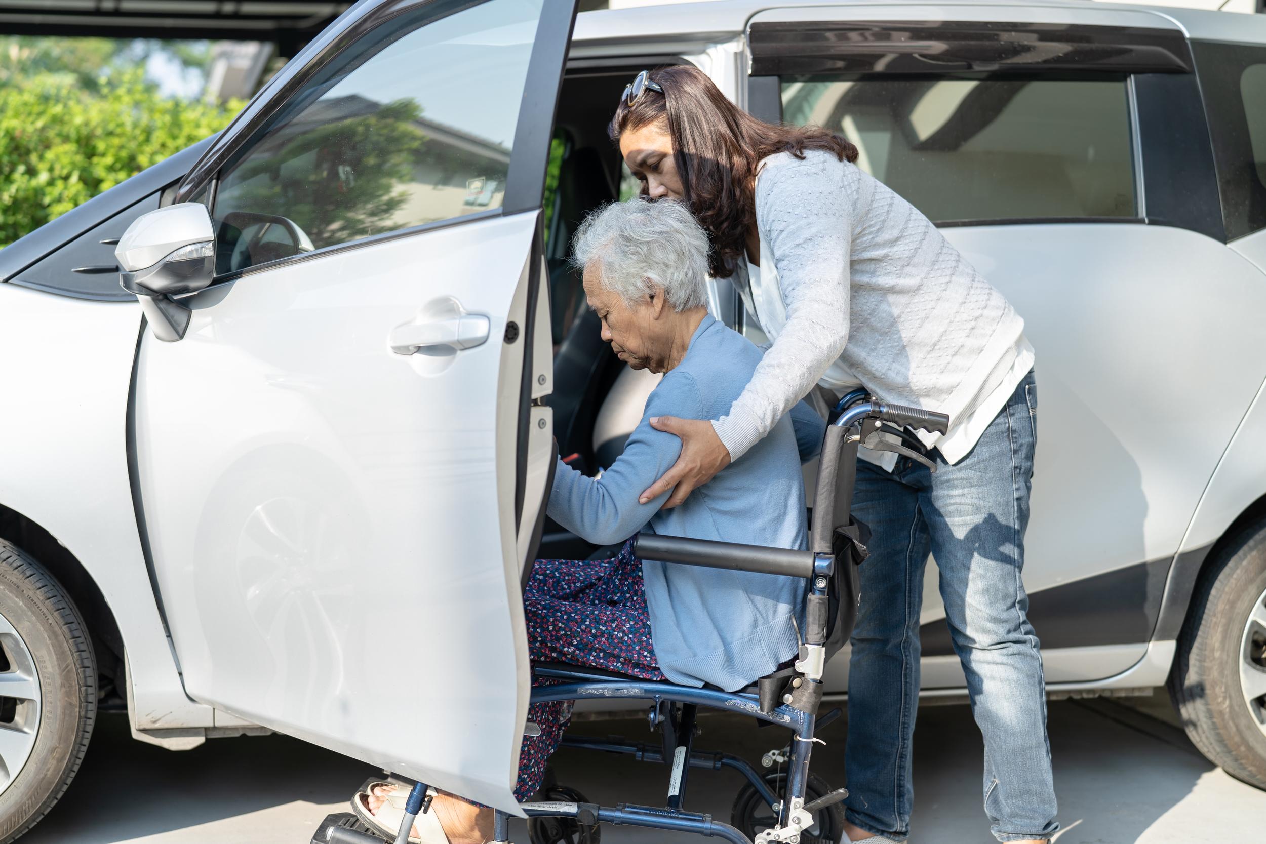 caring-woman-assists-senior-in-wheelchair-near-car-2026-03-19-08-17-17-utc.jpg
