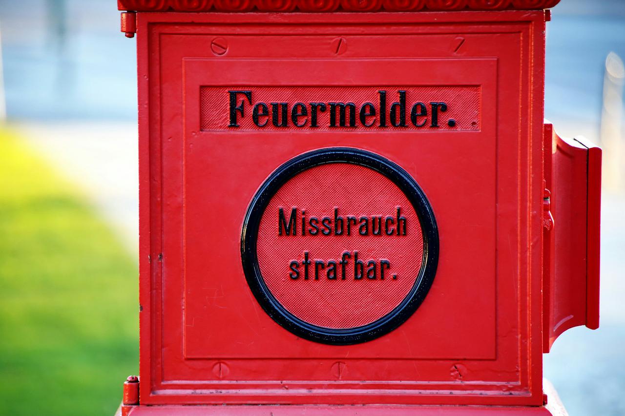 A very old German public fire alarm box. The text says "misuse can be pusnihed as a crime" - translated to today "No fake news!" or "Information integrity first". The box stands in front of Schloss Bellevue which is residence of the Federal President of Germany.