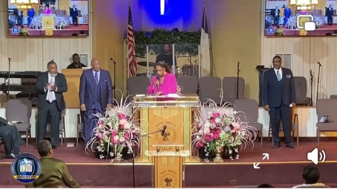 Evangelist Jessica A. Wiley preaching in a fuchsia jacket