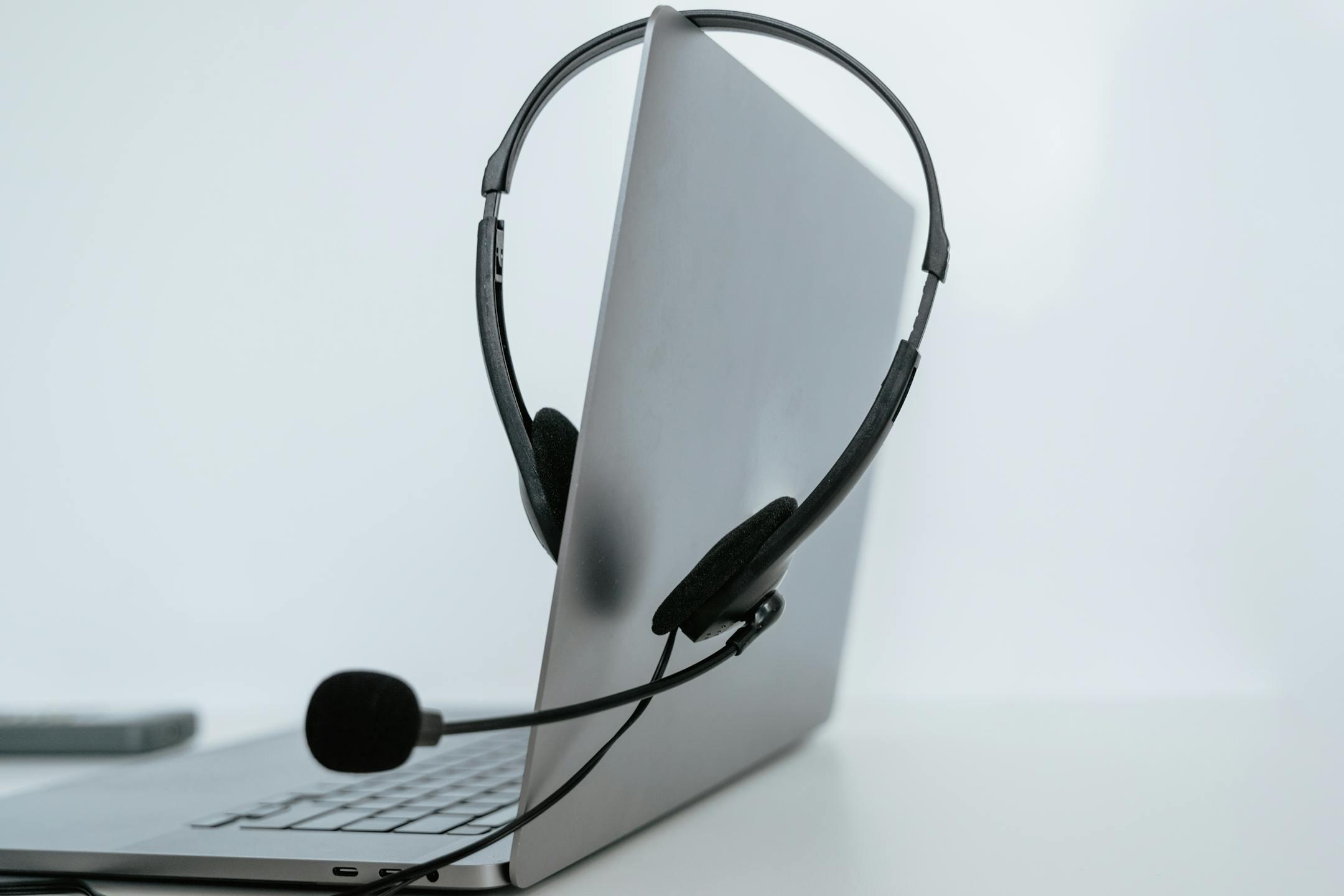 Close-up of a laptop with a headset, symbolizing remote work or online communication.